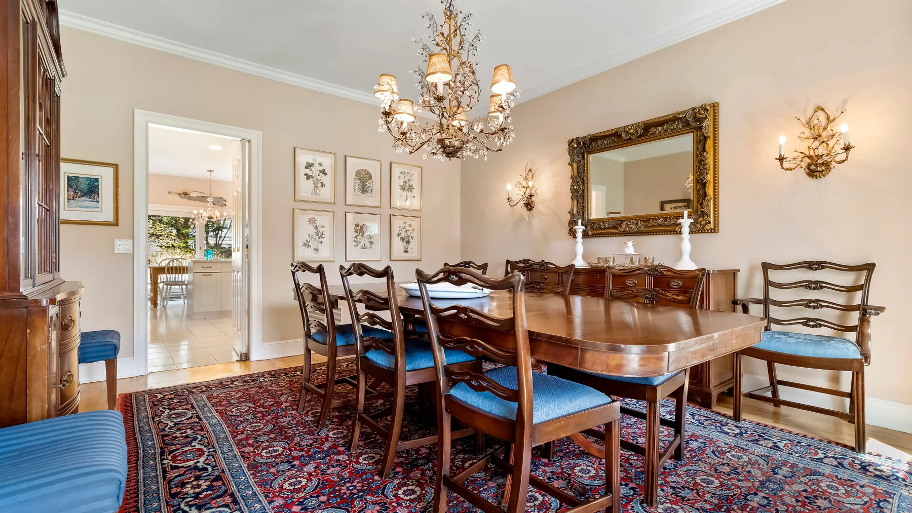 Un comedor formal con una mesa larga de madera bajo una lámpara de araña.