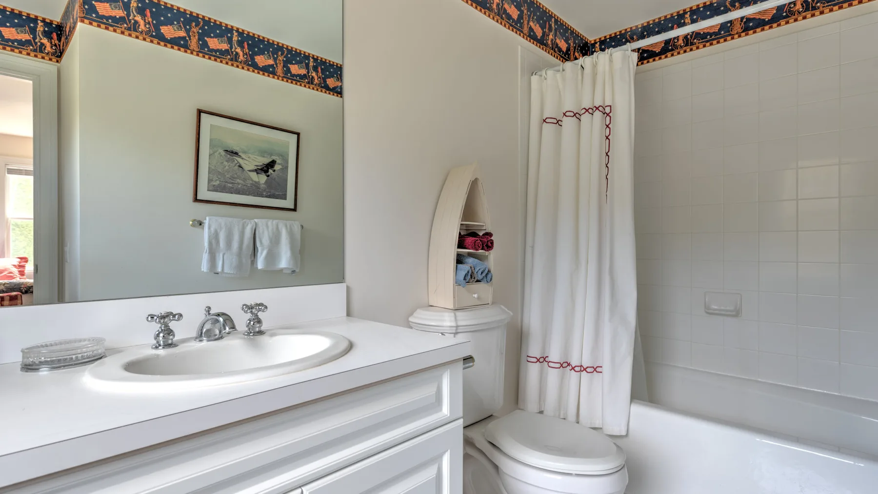Un baño con un lavabo blanco y una bañera detrás de una cortina de ducha.