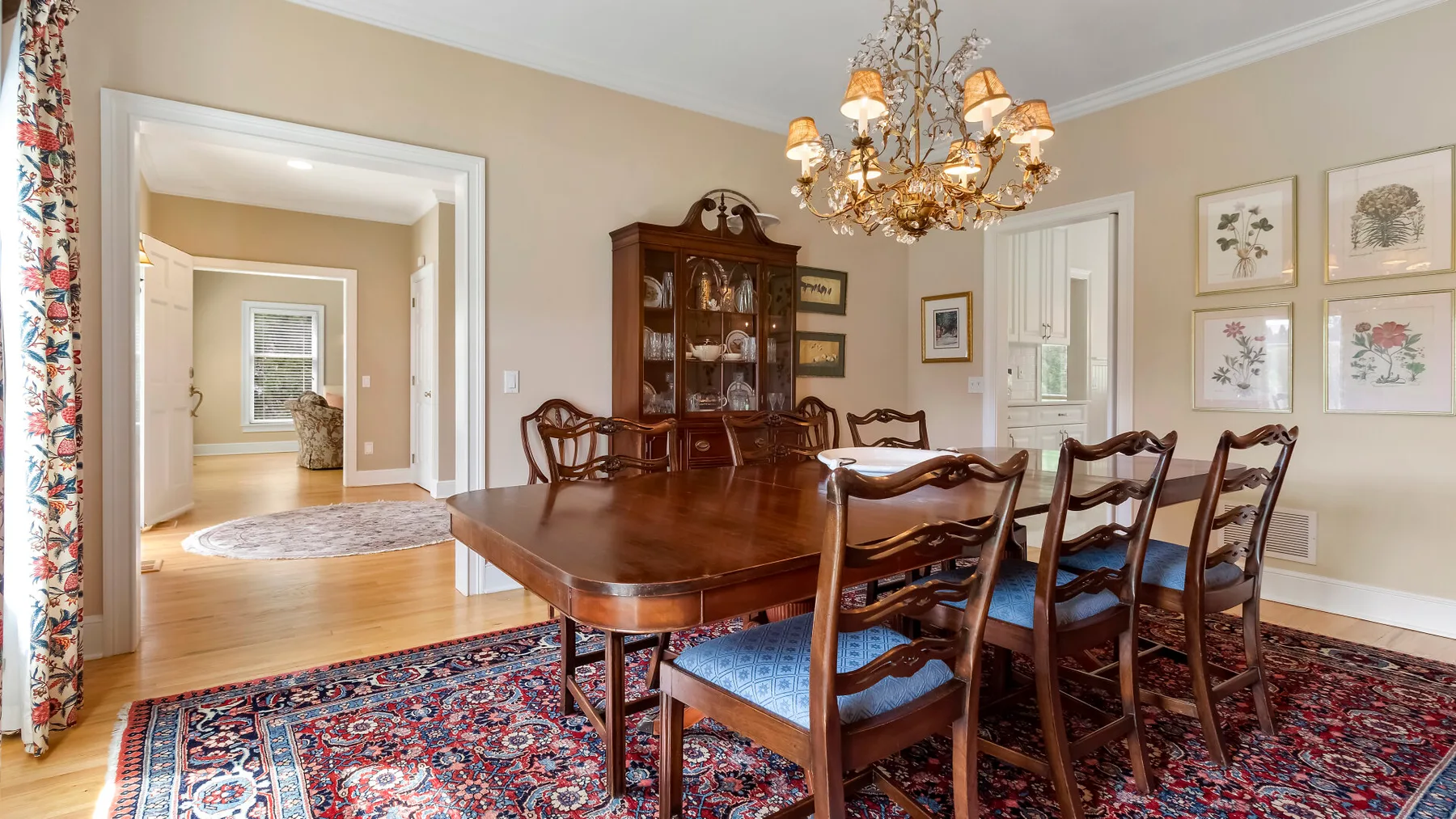 Un comedor formal con una mesa de madera, sillas y una lámpara de araña.