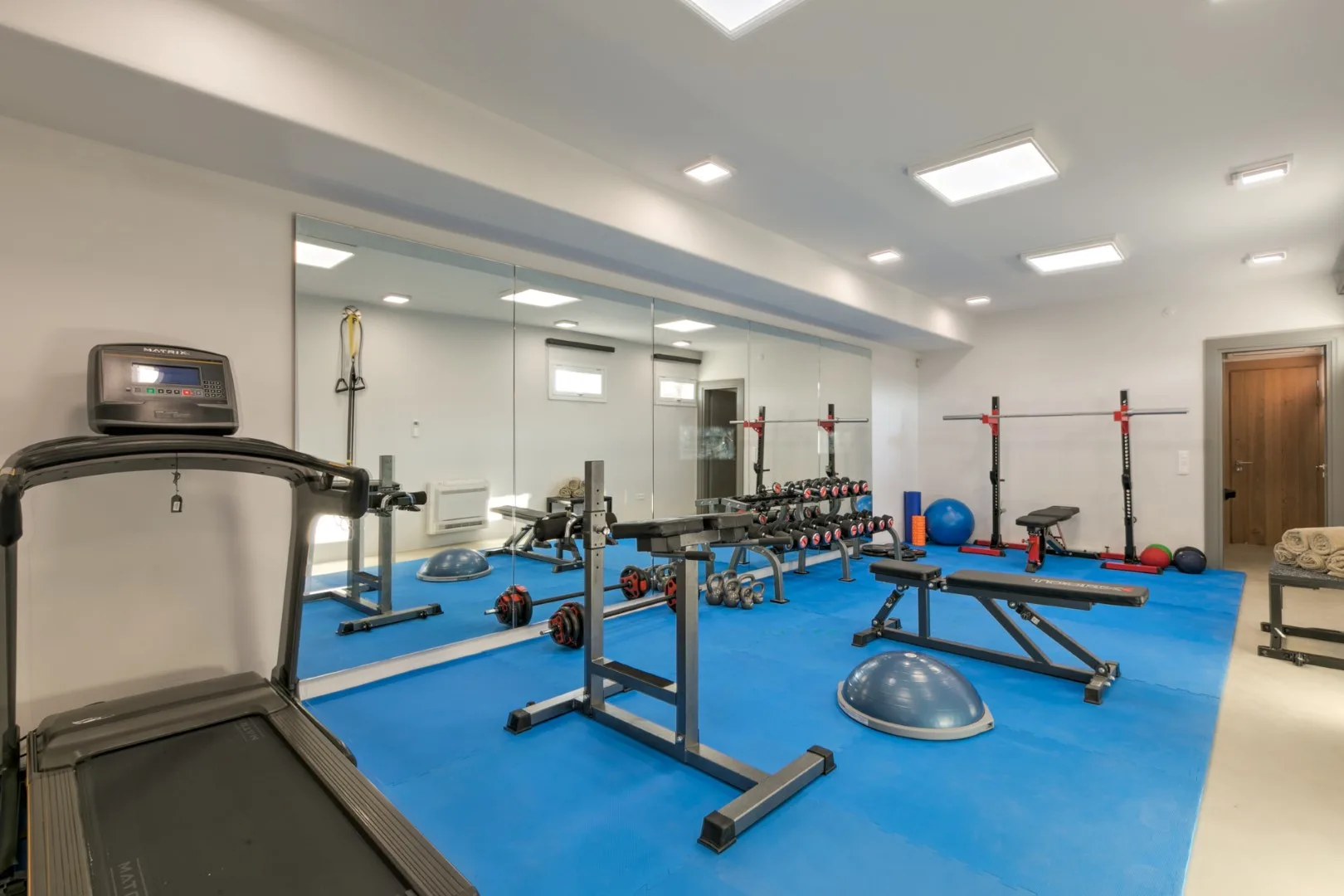 A fitness room with exercise equipment on a blue floor.