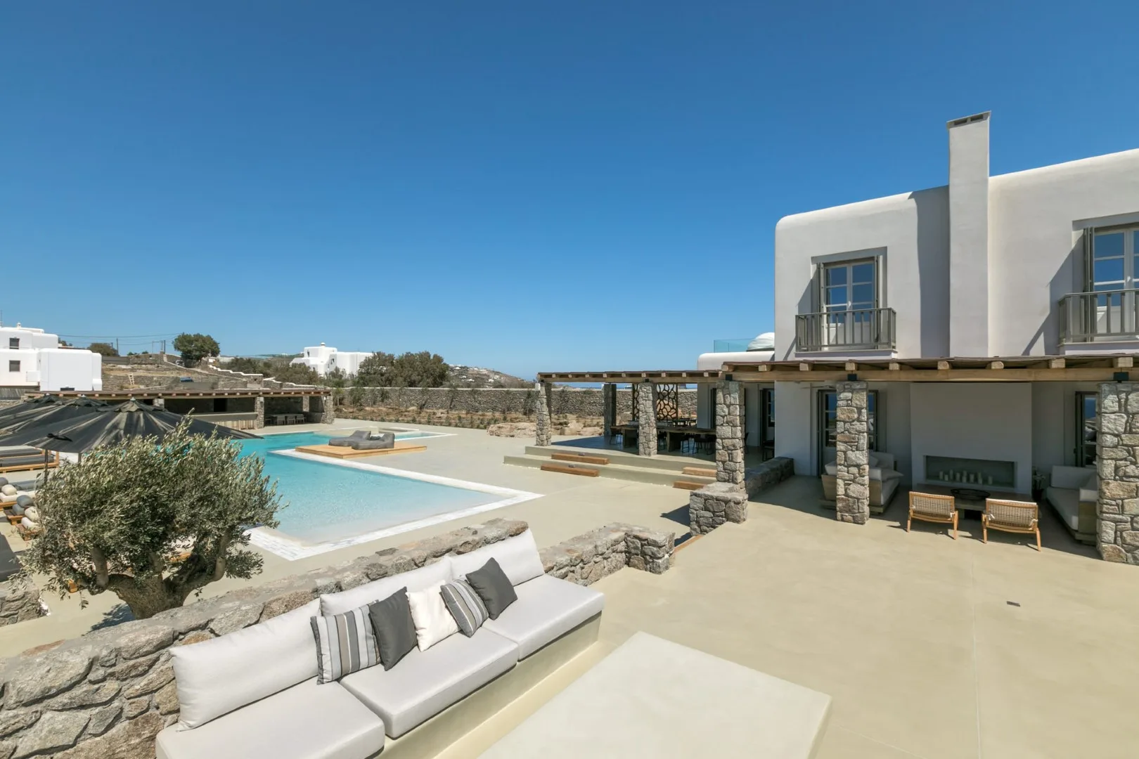 A villa terrace with a swimming pool and outdoor seating.
