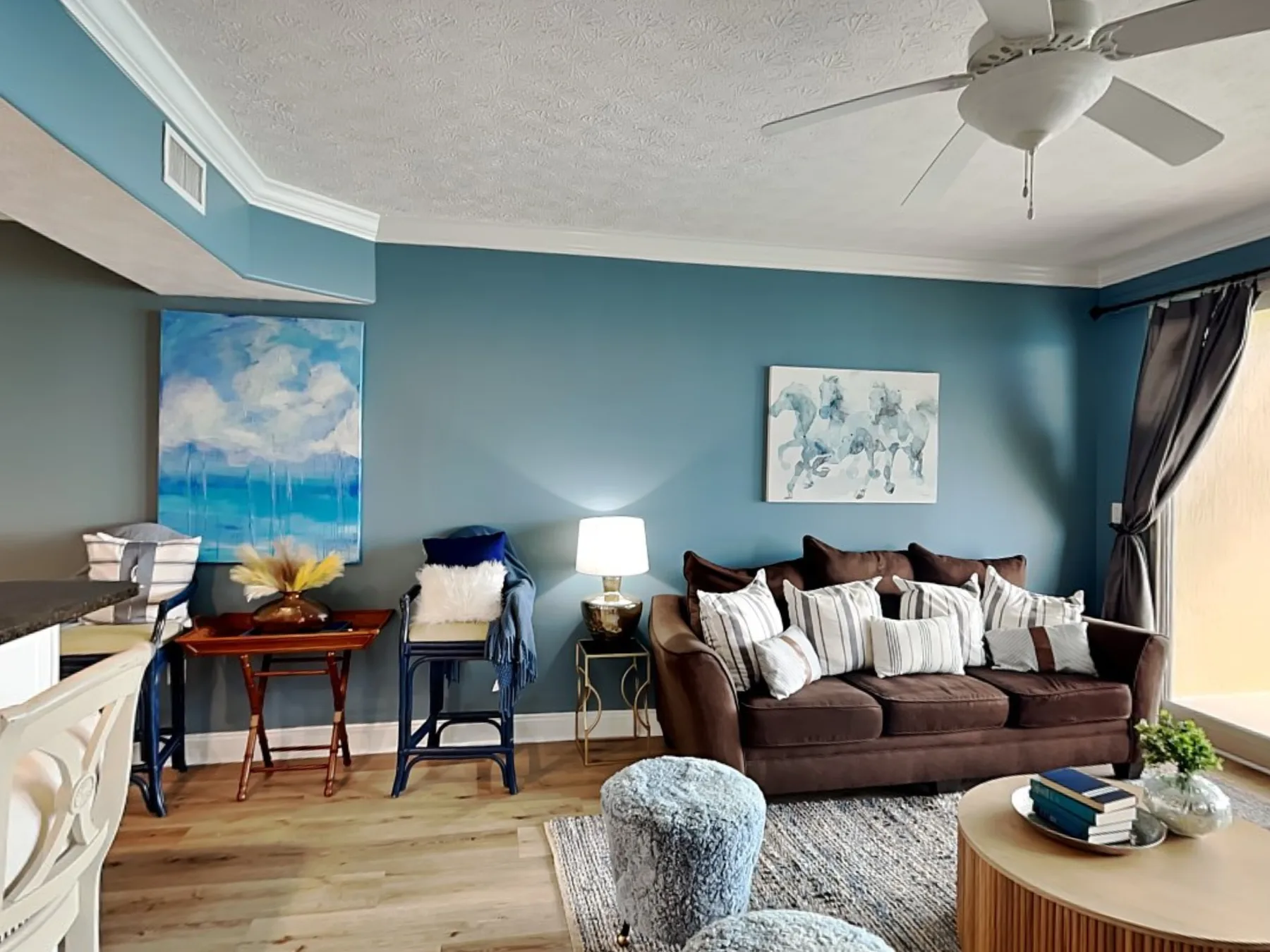 Living room with seating, framed artwork, and a ceiling fan.