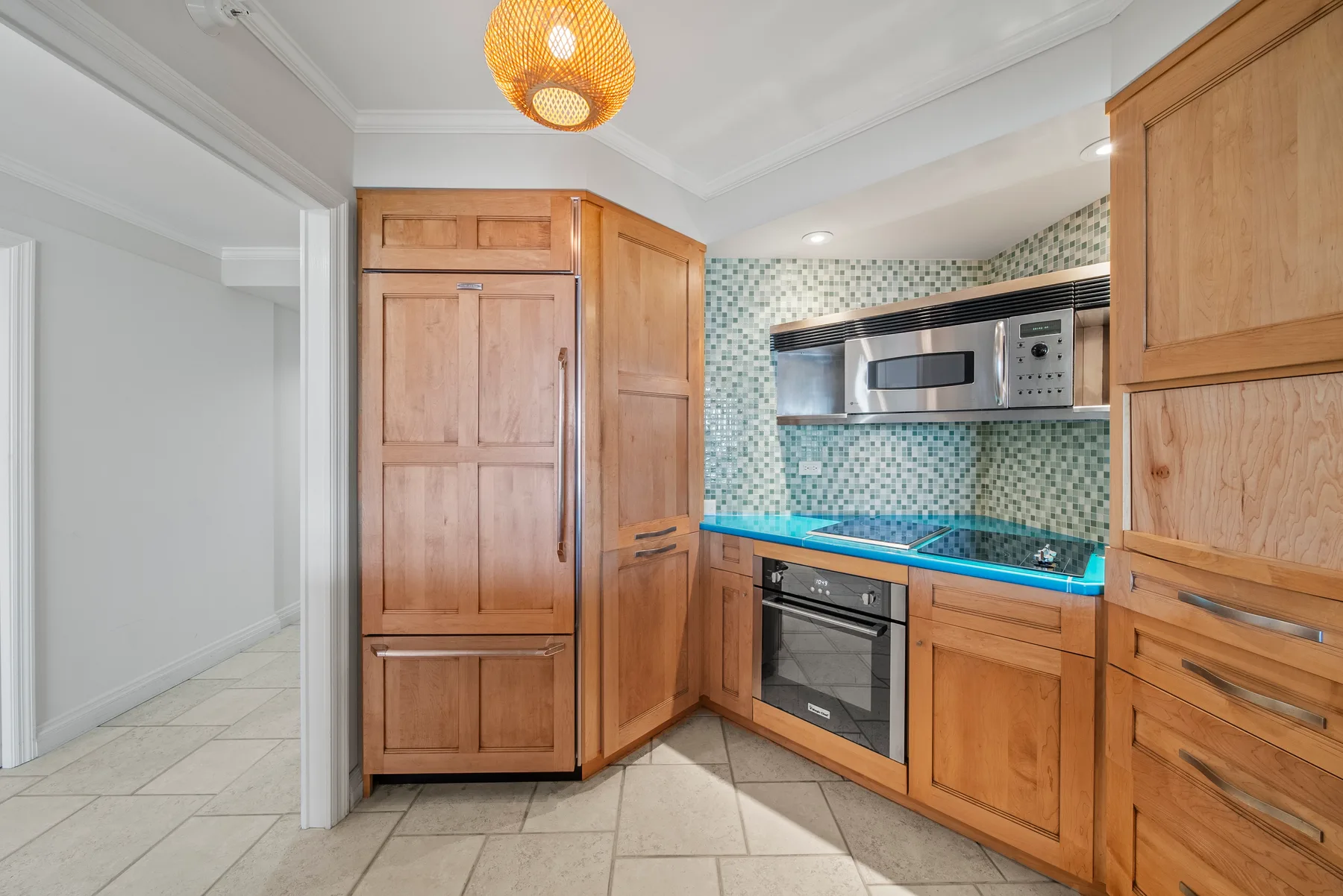 Una cocina con gabinetes de madera, horno empotrado y salpicadero estampado.