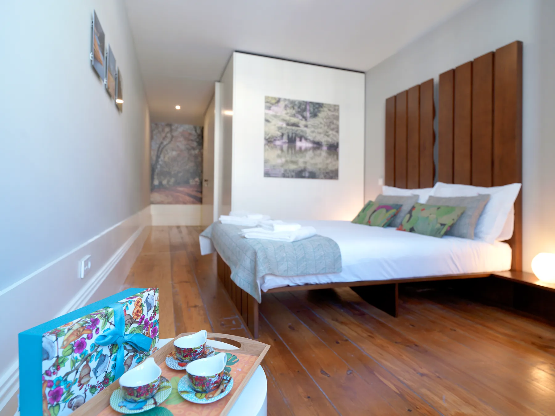 A bedroom with a double bed and a small table set with cups.