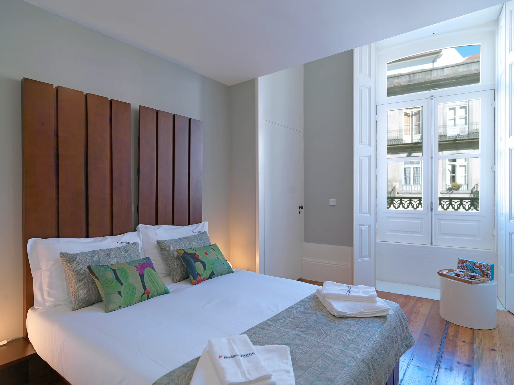 Un dormitorio con una cama bien tendida y paneles altos detrás.
