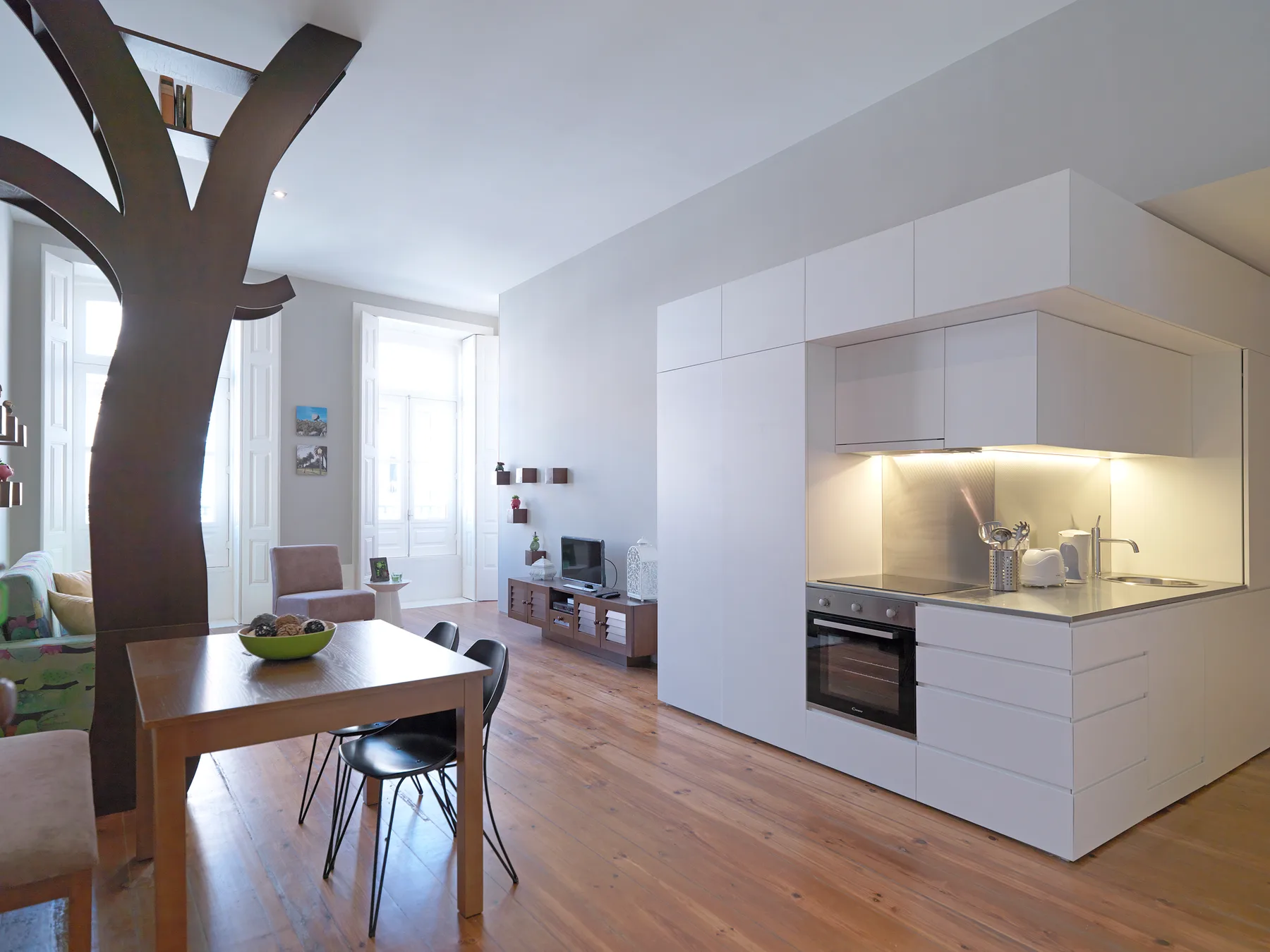 An open-plan living and dining area with a table beside a compact kitchen.
