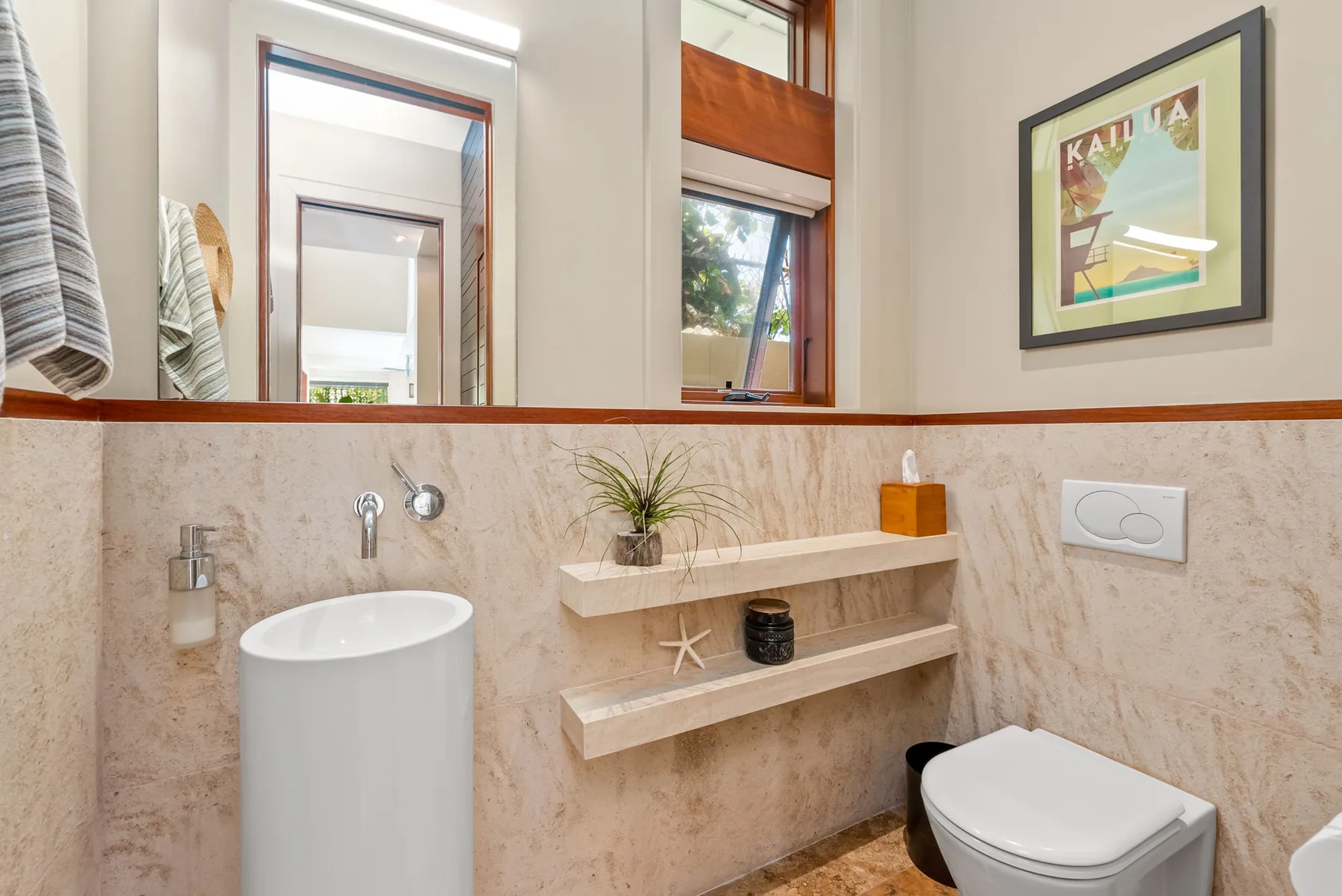 A bathroom vanity area with a basin, wall mirror, and toilet.