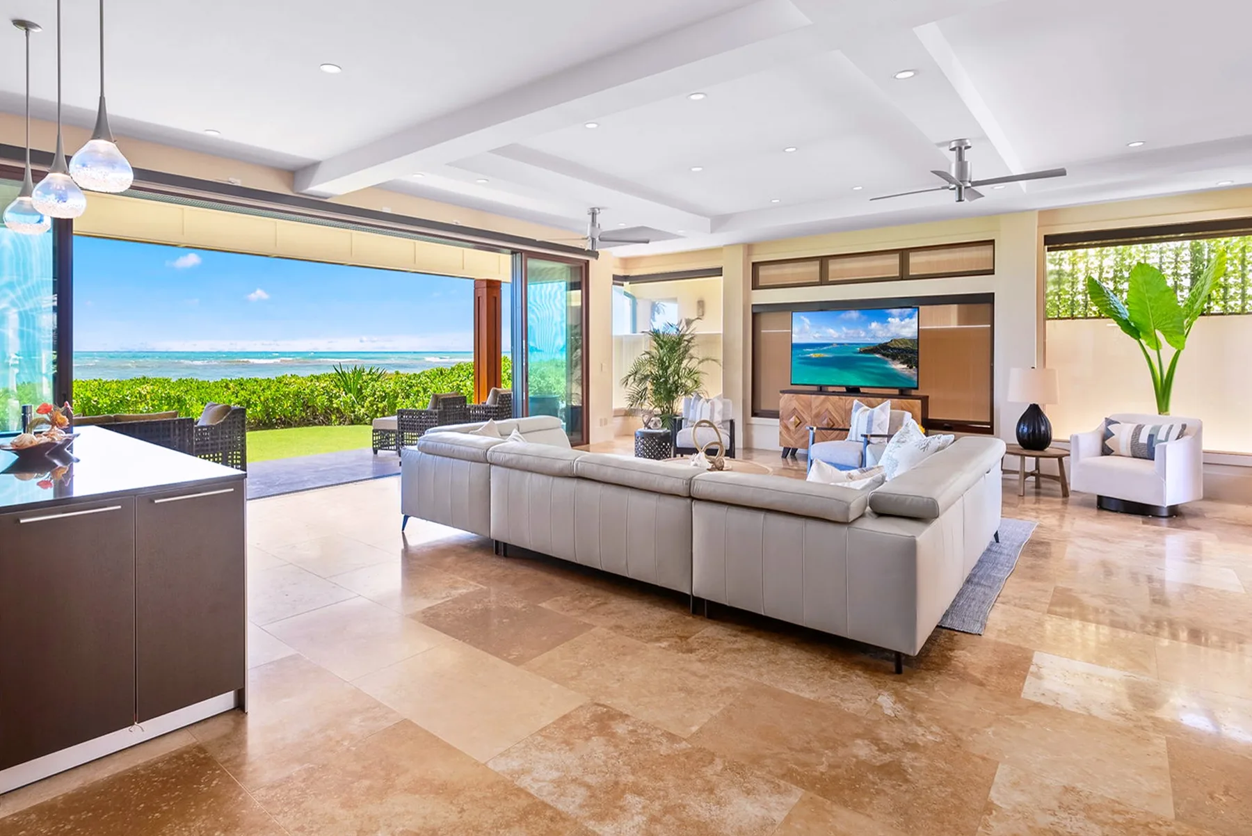 A spacious living room opens onto a patio with views of the ocean.