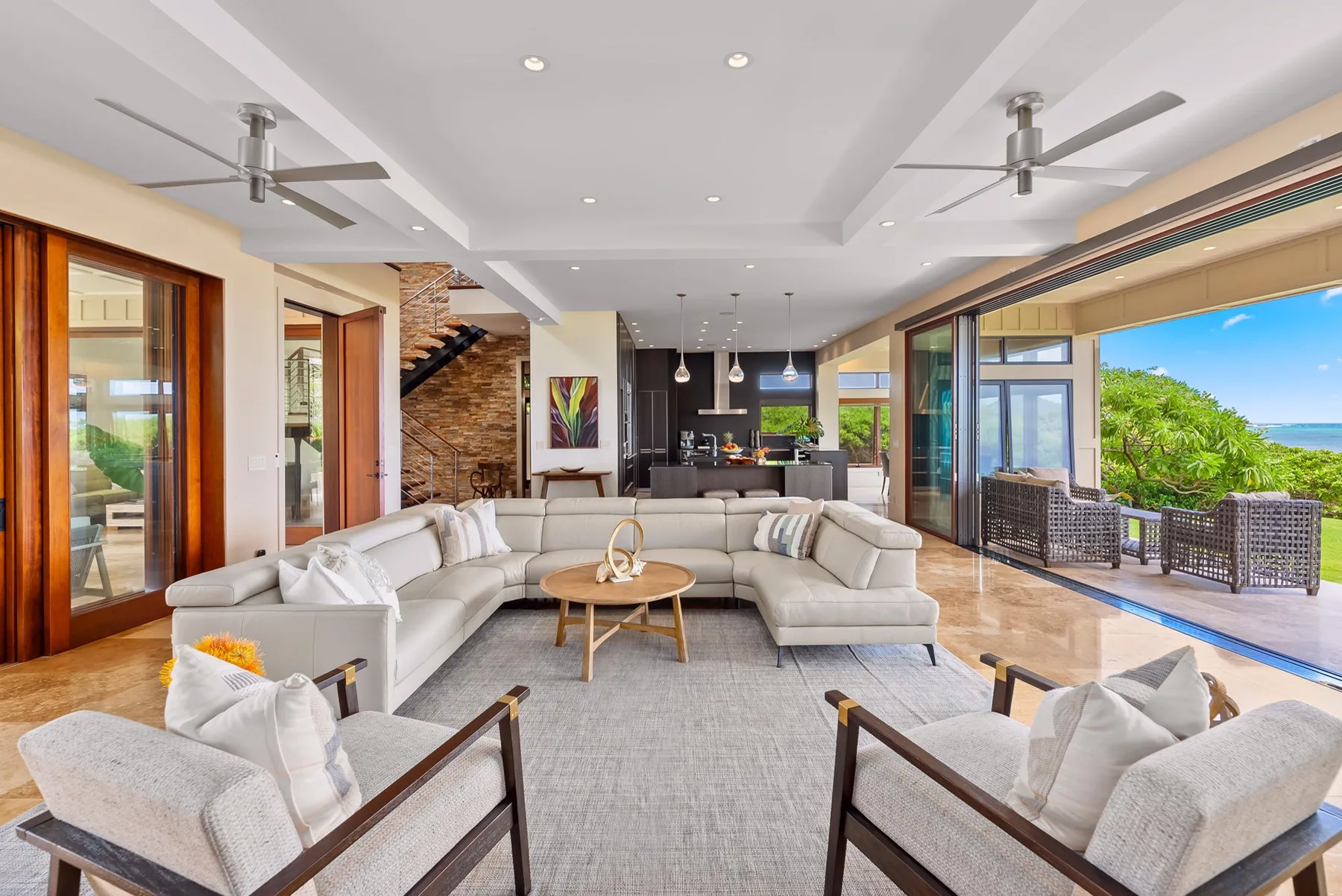 A spacious living room opens onto a patio with seating and a pool.