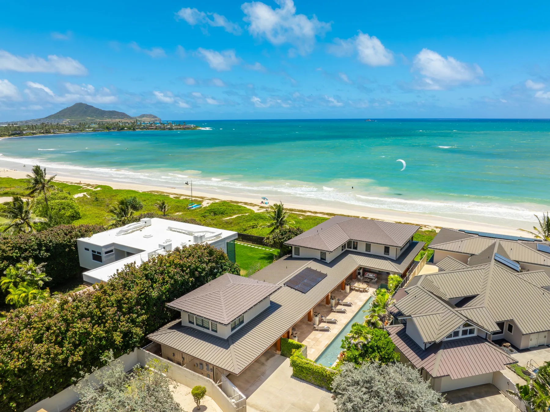 Coastal homes overlook a sandy beach and turquoise ocean.