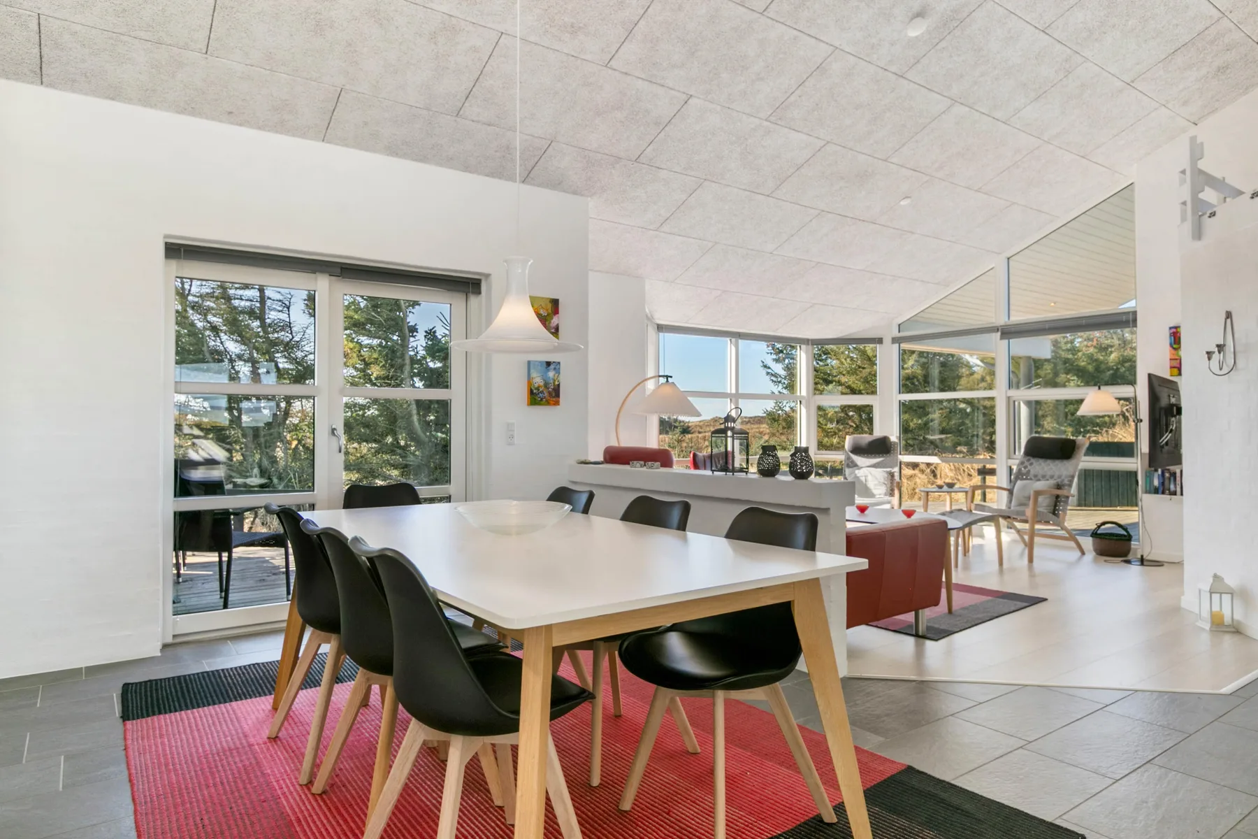 An open dining and living area with a table, seating, and large windows.