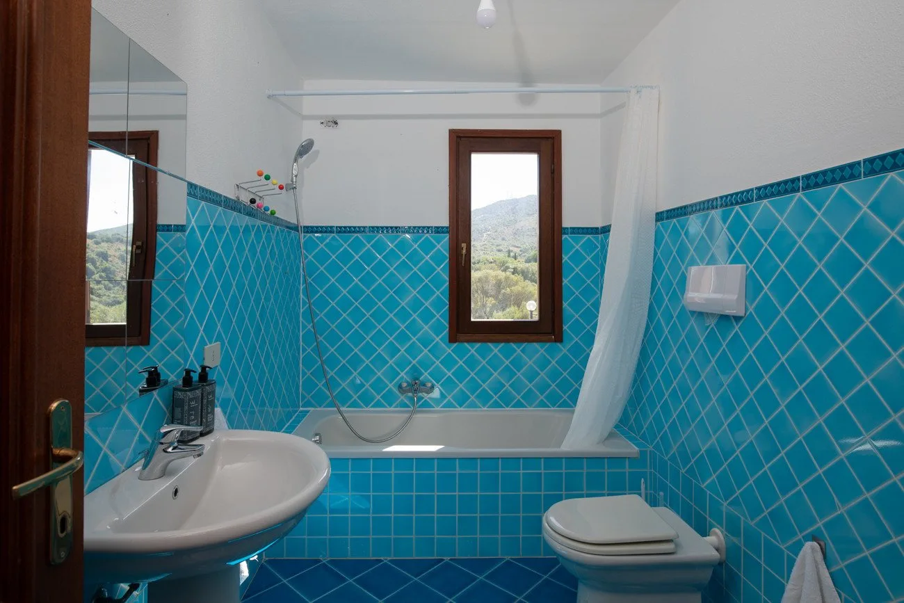 A tiled bathroom with a bathtub, sink, and toilet.