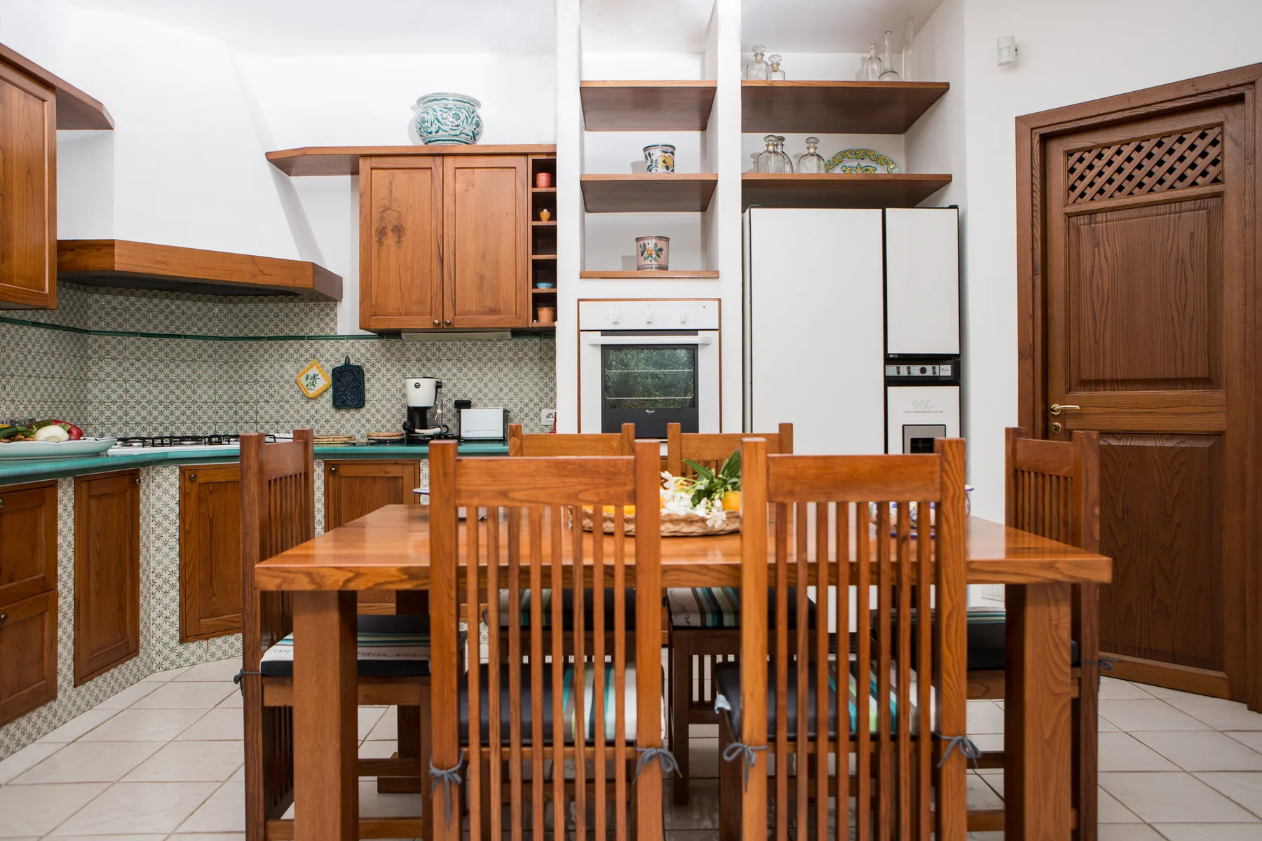 Una cocina y comedor con una mesa de madera y sillas.