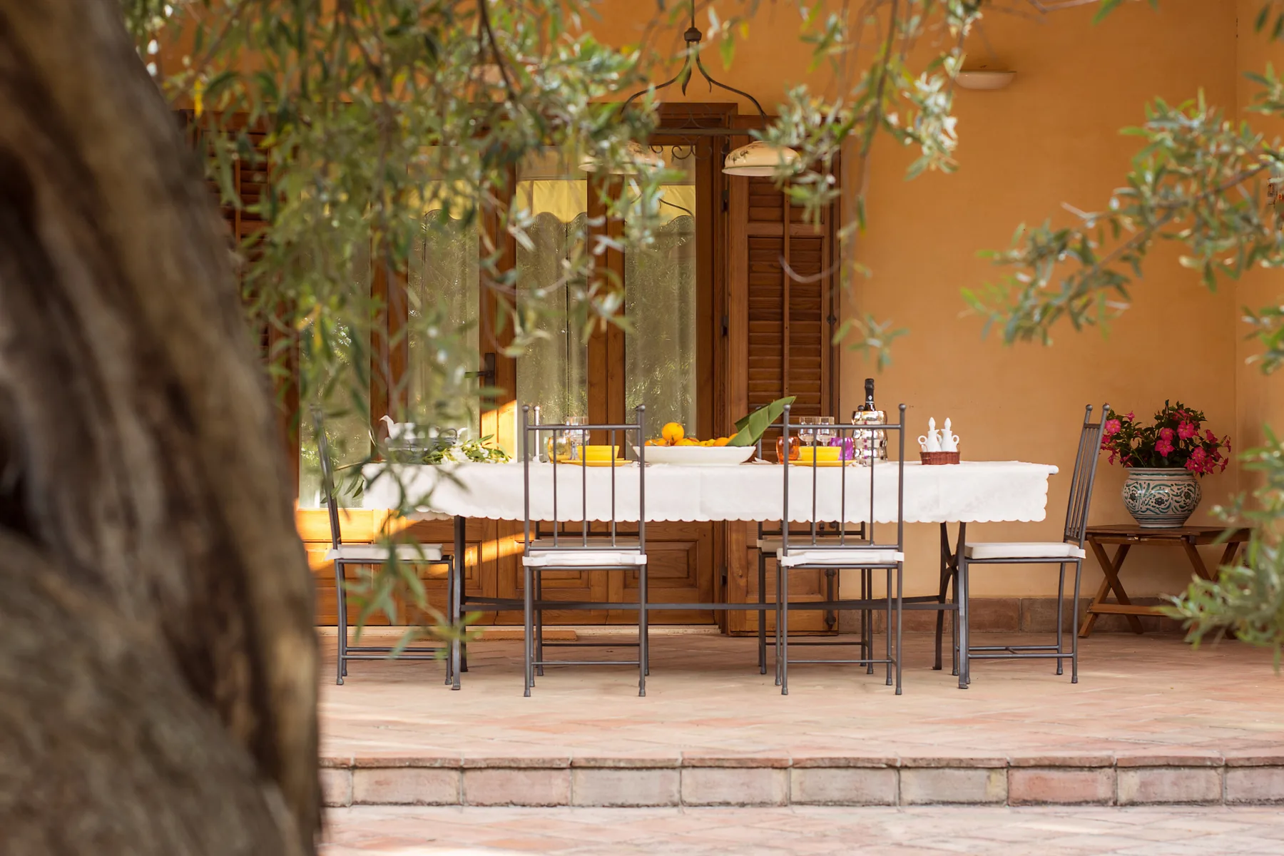 Una zona de comedor al aire libre con una mesa larga sobre un patio embaldosado.