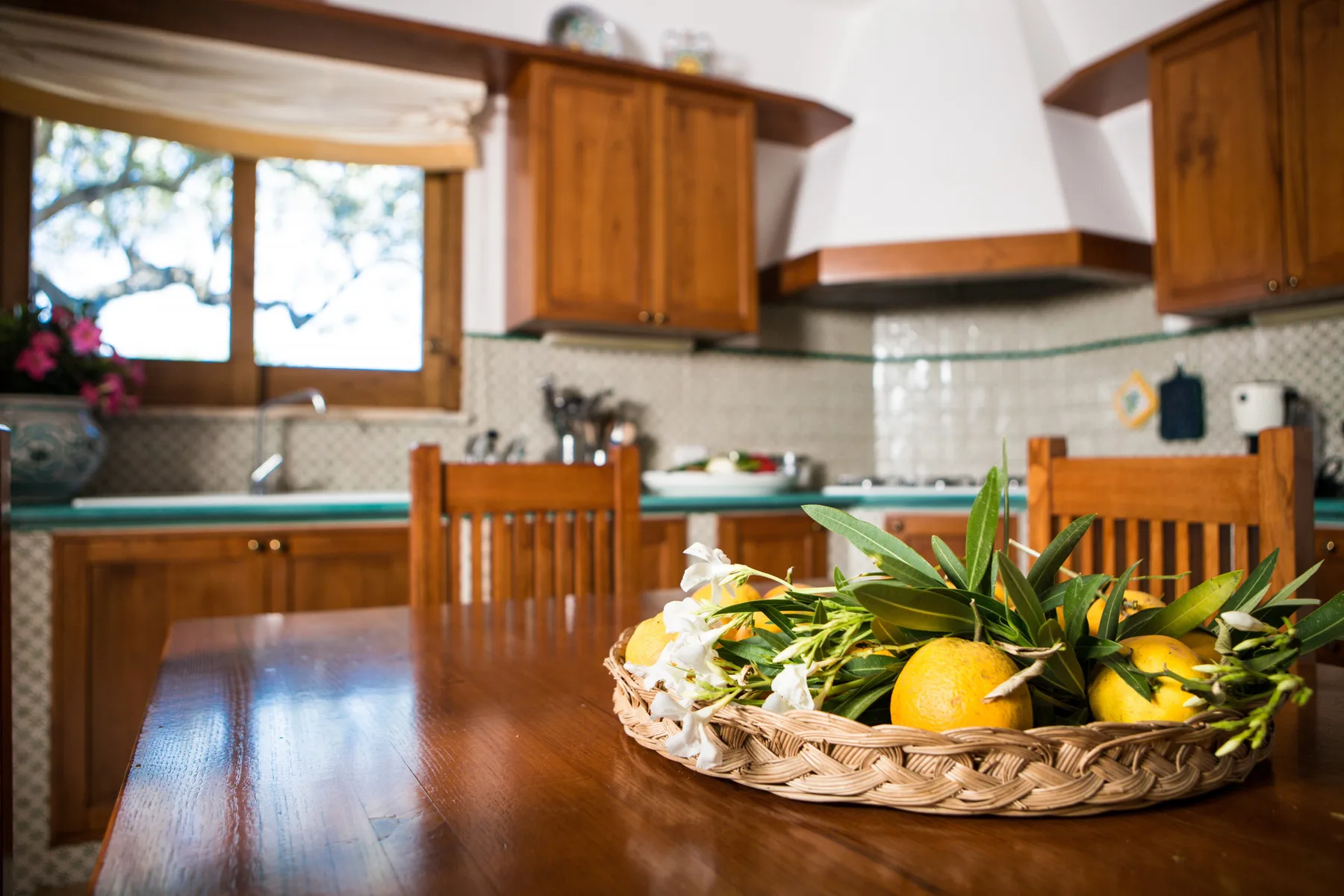 Una cocina con armarios de madera y una cesta de frutas sobre la mesa.