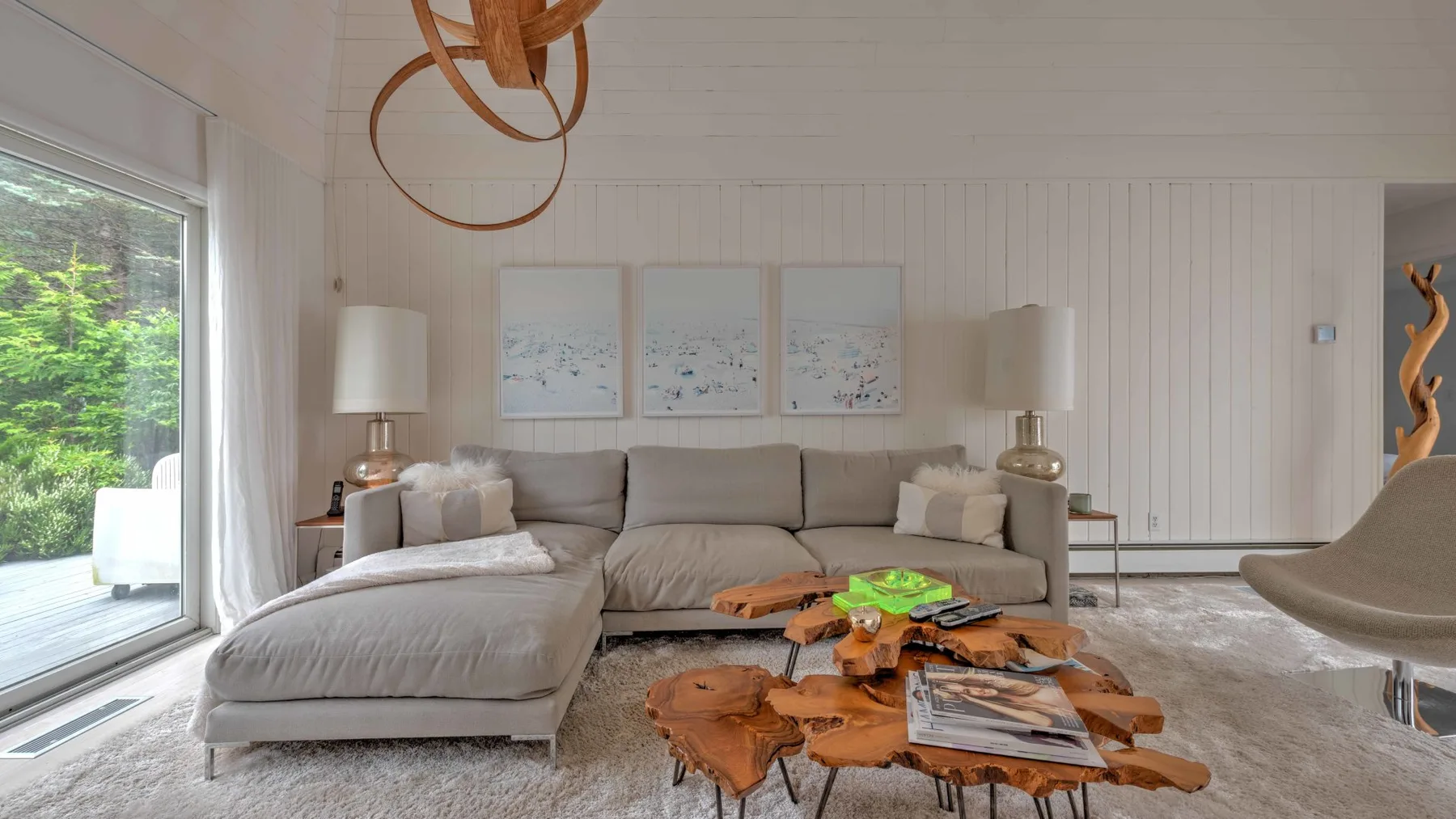 A bright living room with neutral seating and a low wooden coffee table.