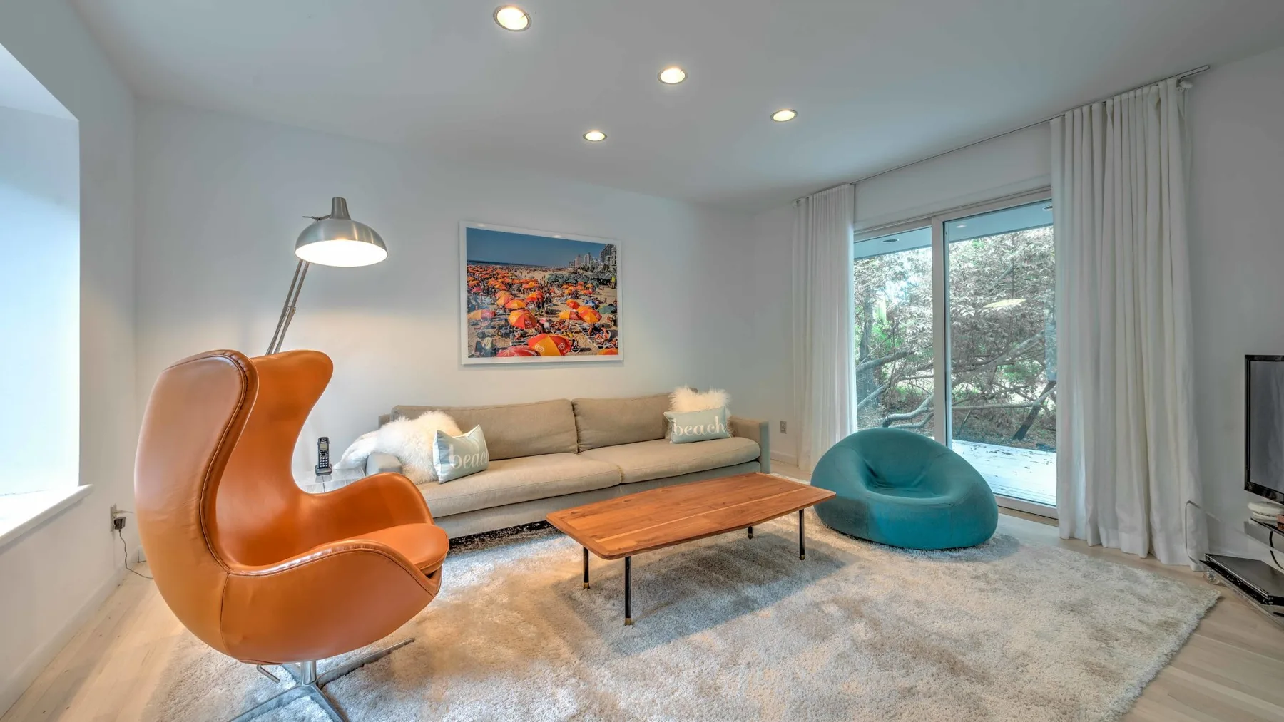 A bright living room with a sofa, coffee table, and large windows.