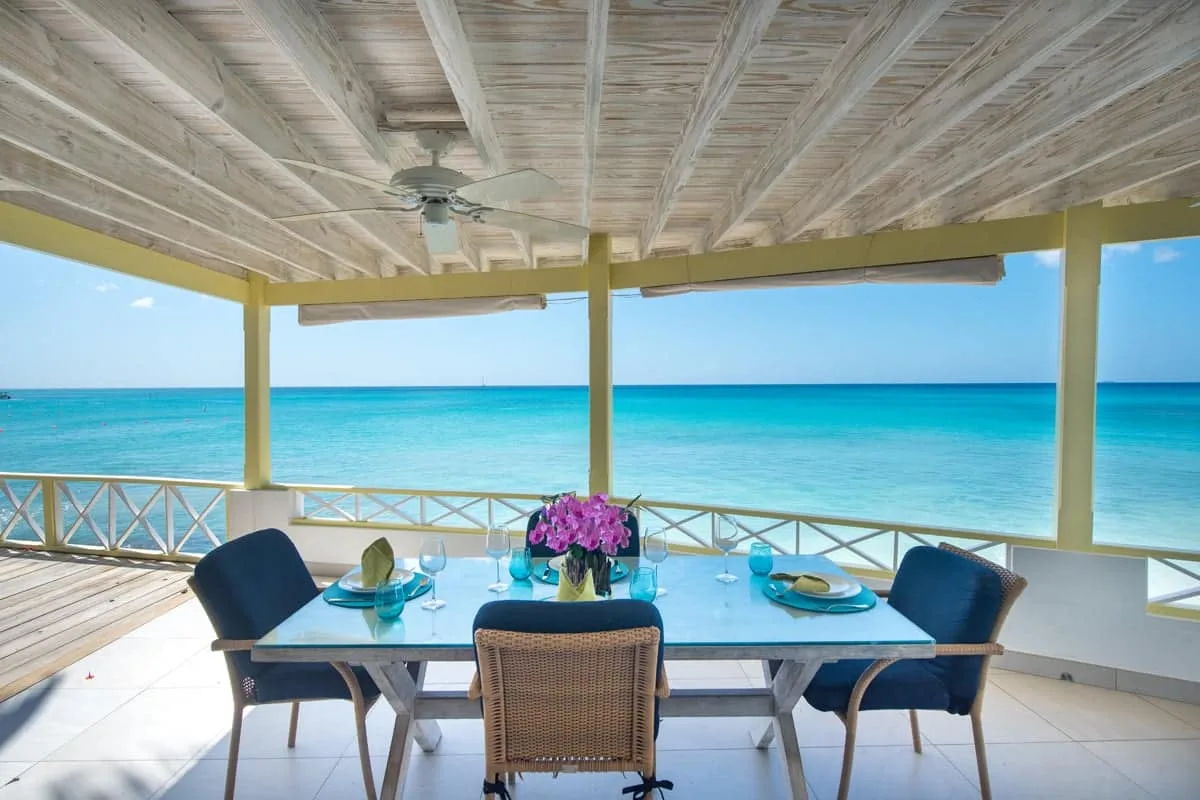 A covered dining area overlooks the turquoise sea.