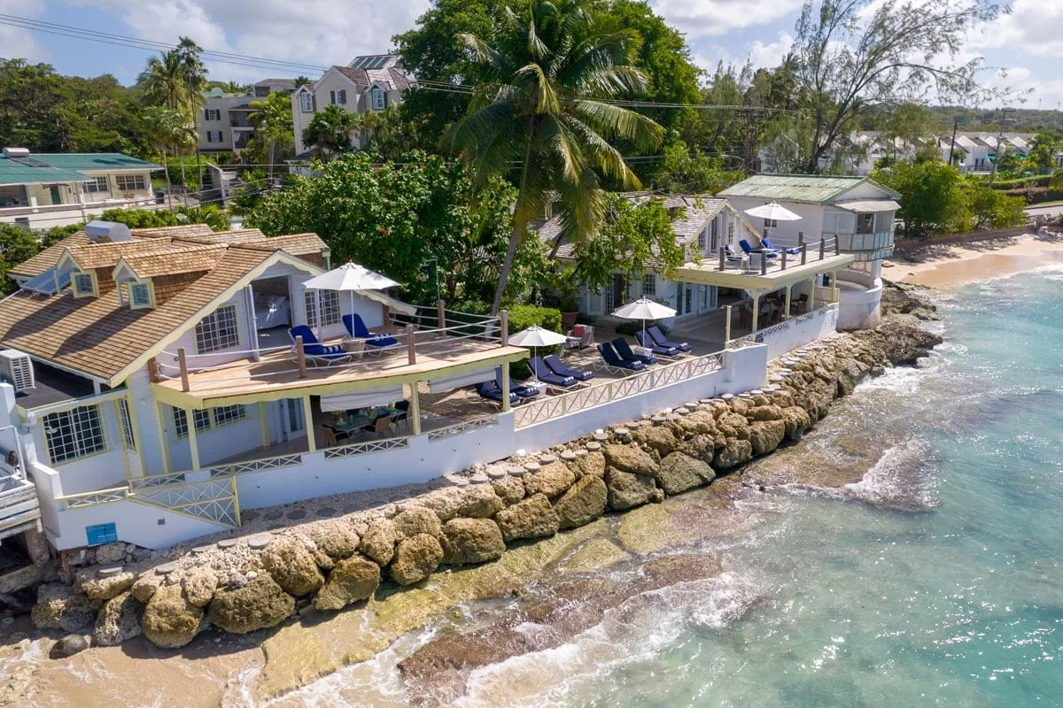 A coastal property with outdoor seating overlooks the rocky shoreline.