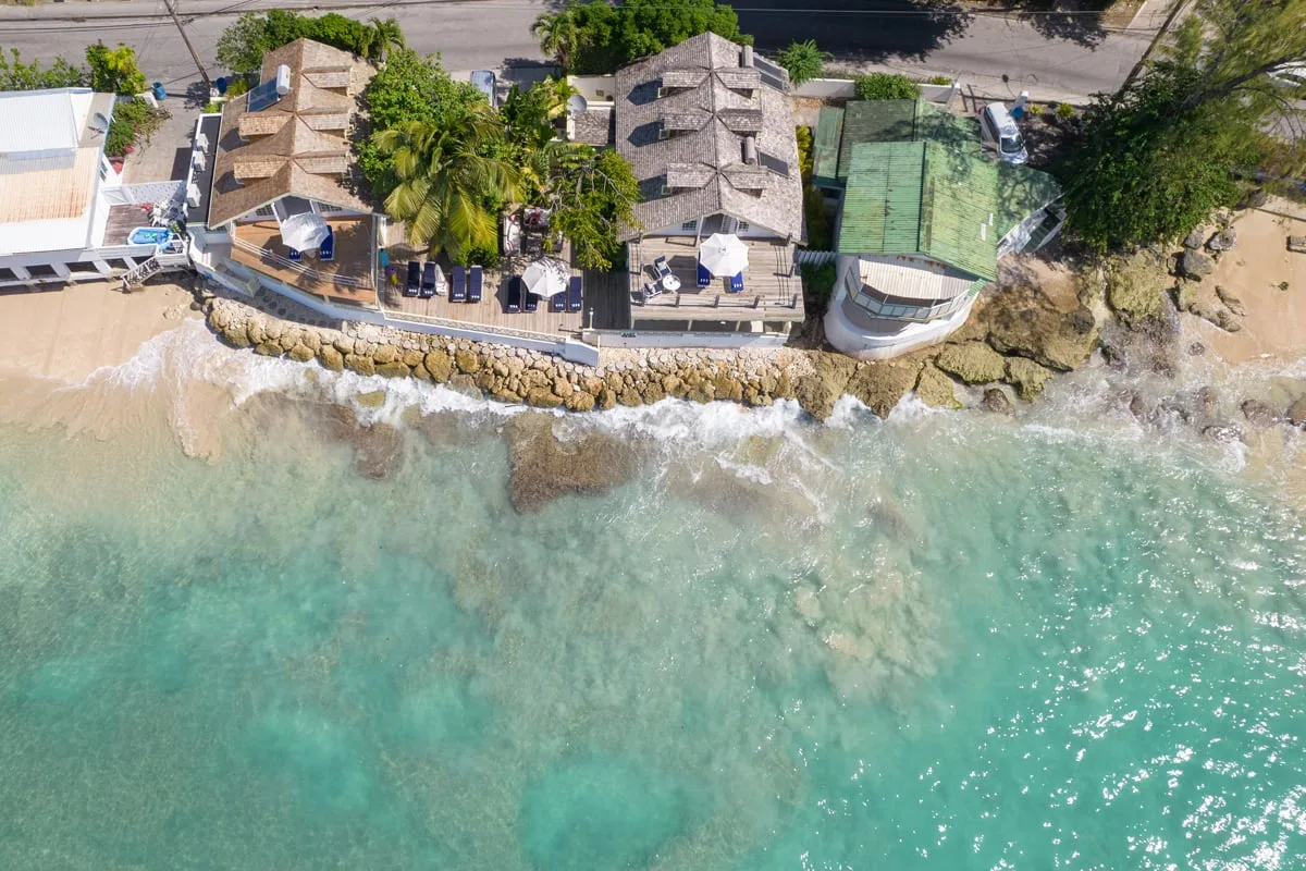An aerial view of waterfront buildings along a rocky shoreline.