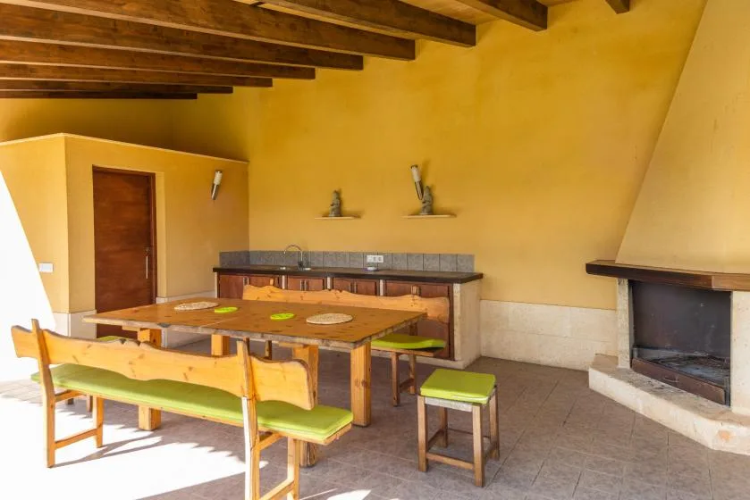 Un comedor con una mesa de madera y asientos junto a una chimenea.