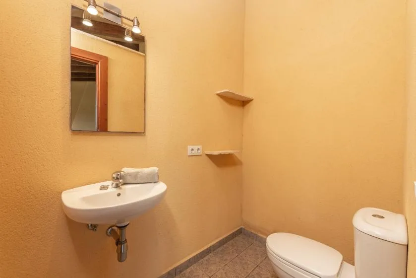 Un baño pequeño con un lavabo de pared y un inodoro.