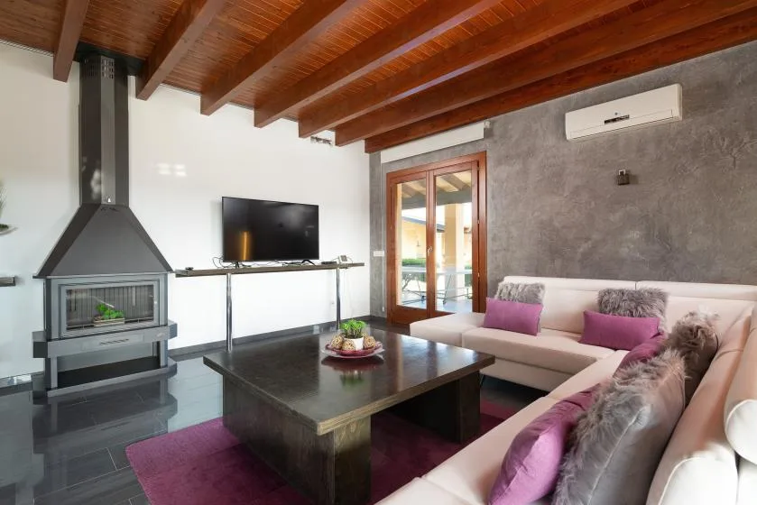 Una sala de estar con asientos, una mesa de centro y una chimenea bajo un techo de madera.