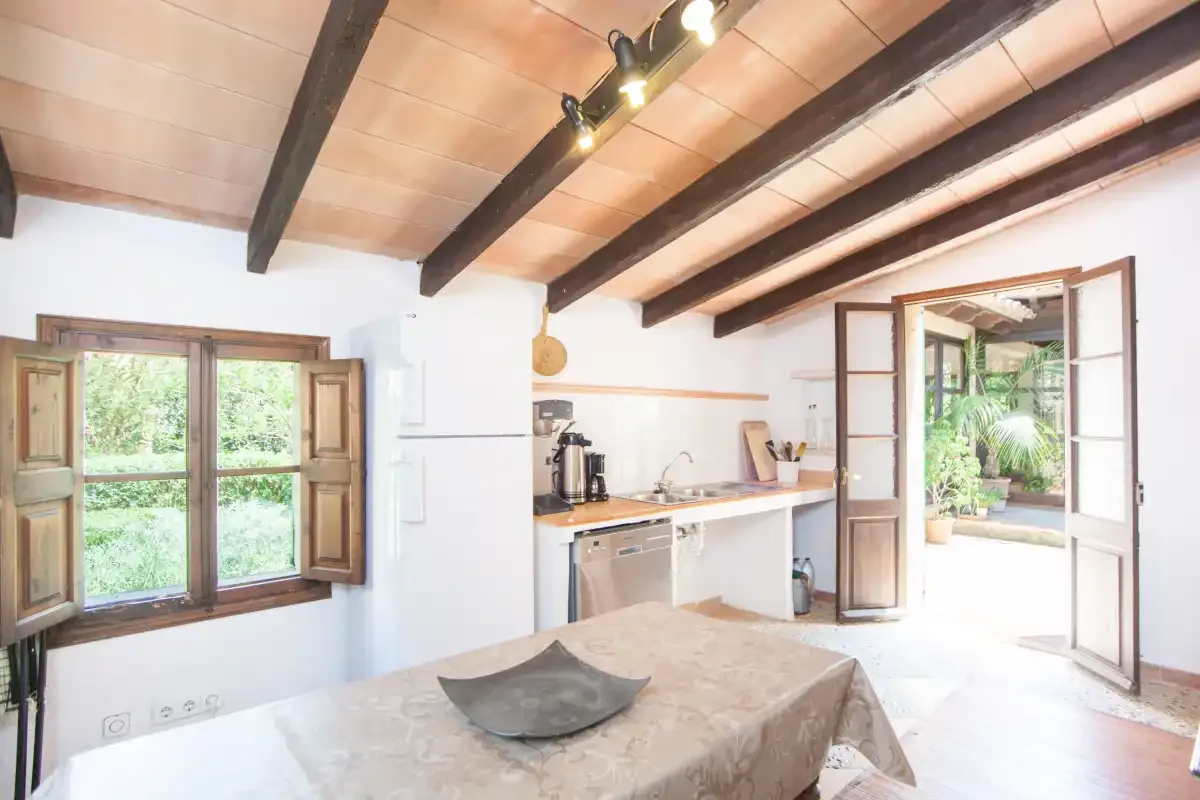 Una cocina luminosa con zona de comedor se abre a un patio frondoso.