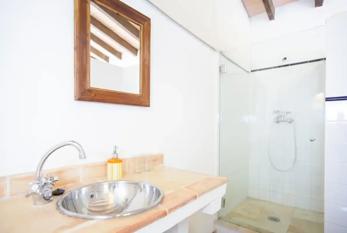 Un baño con lavabo y ducha de cristal.