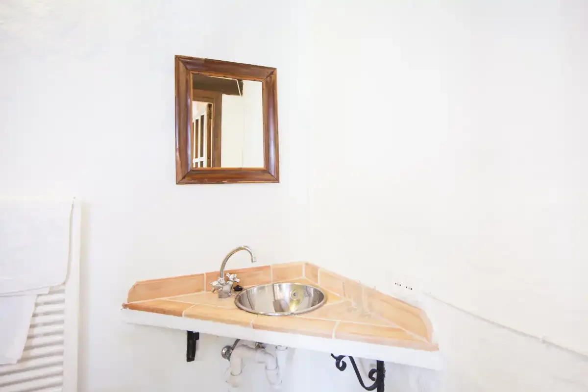 Un lavabo de baño con un espejo con marco de madera.