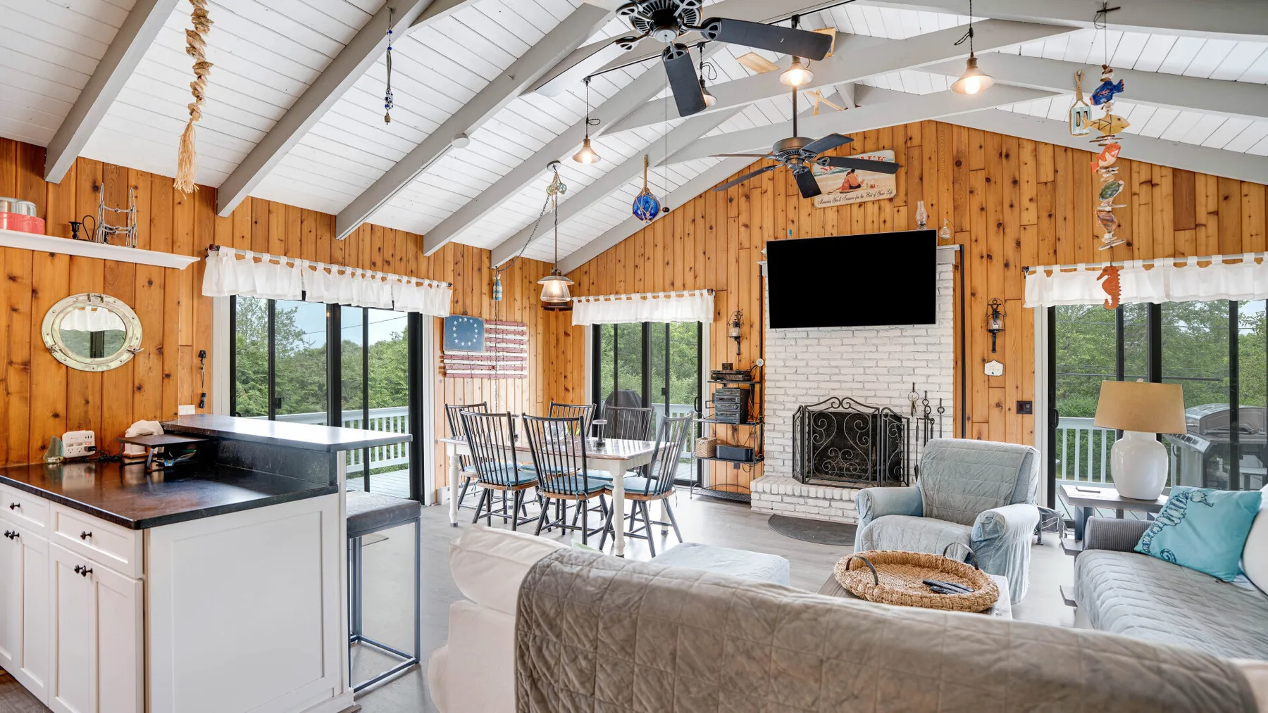 Una luminosa sala de estar y comedor diáfanos con isla de cocina y chimenea.