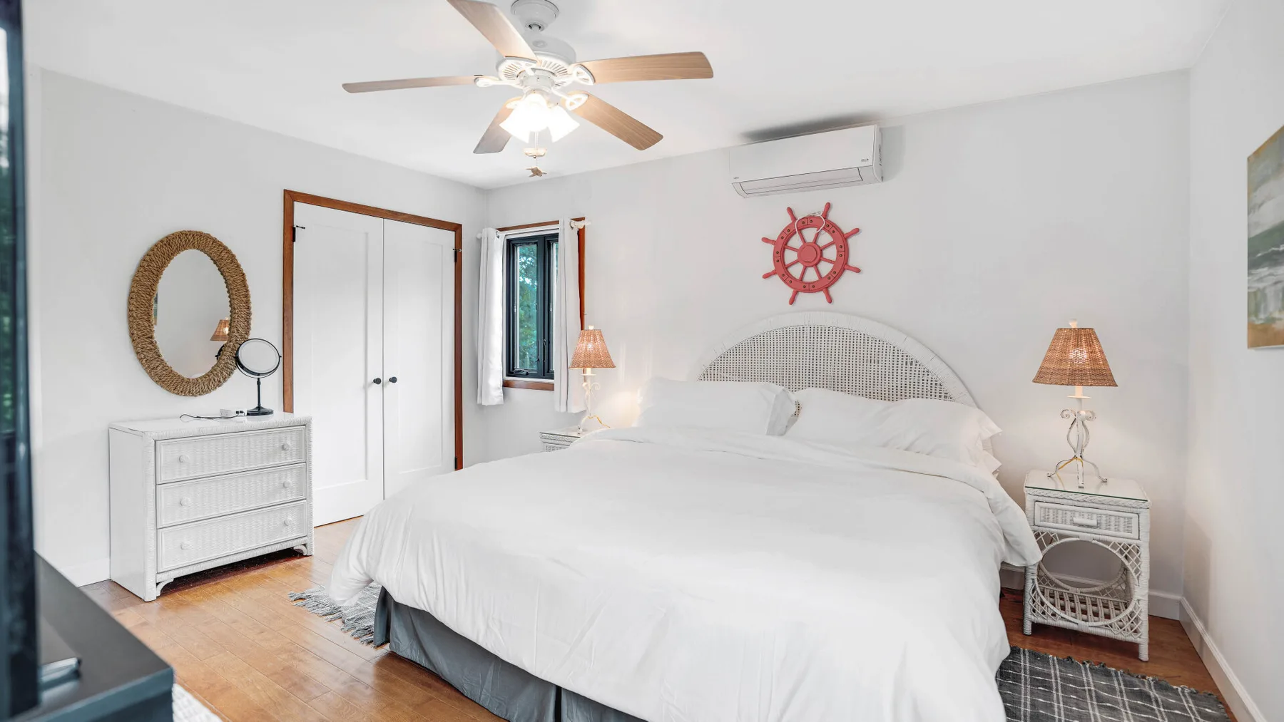Un dormitorio luminoso con una cama grande, mesitas de noche y un ventilador de techo.