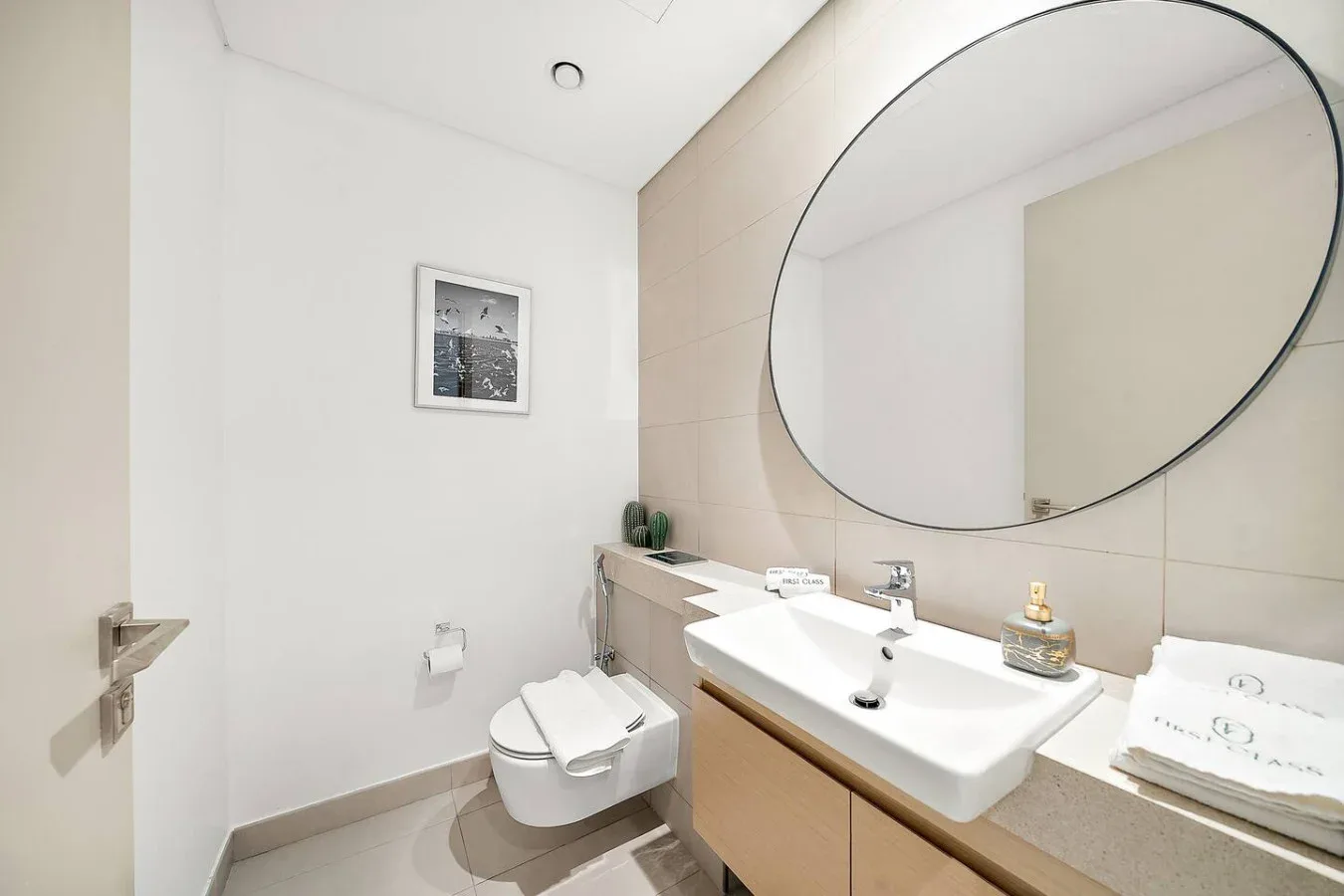 Un baño luminoso con lavabo, espejo grande e inodoro.