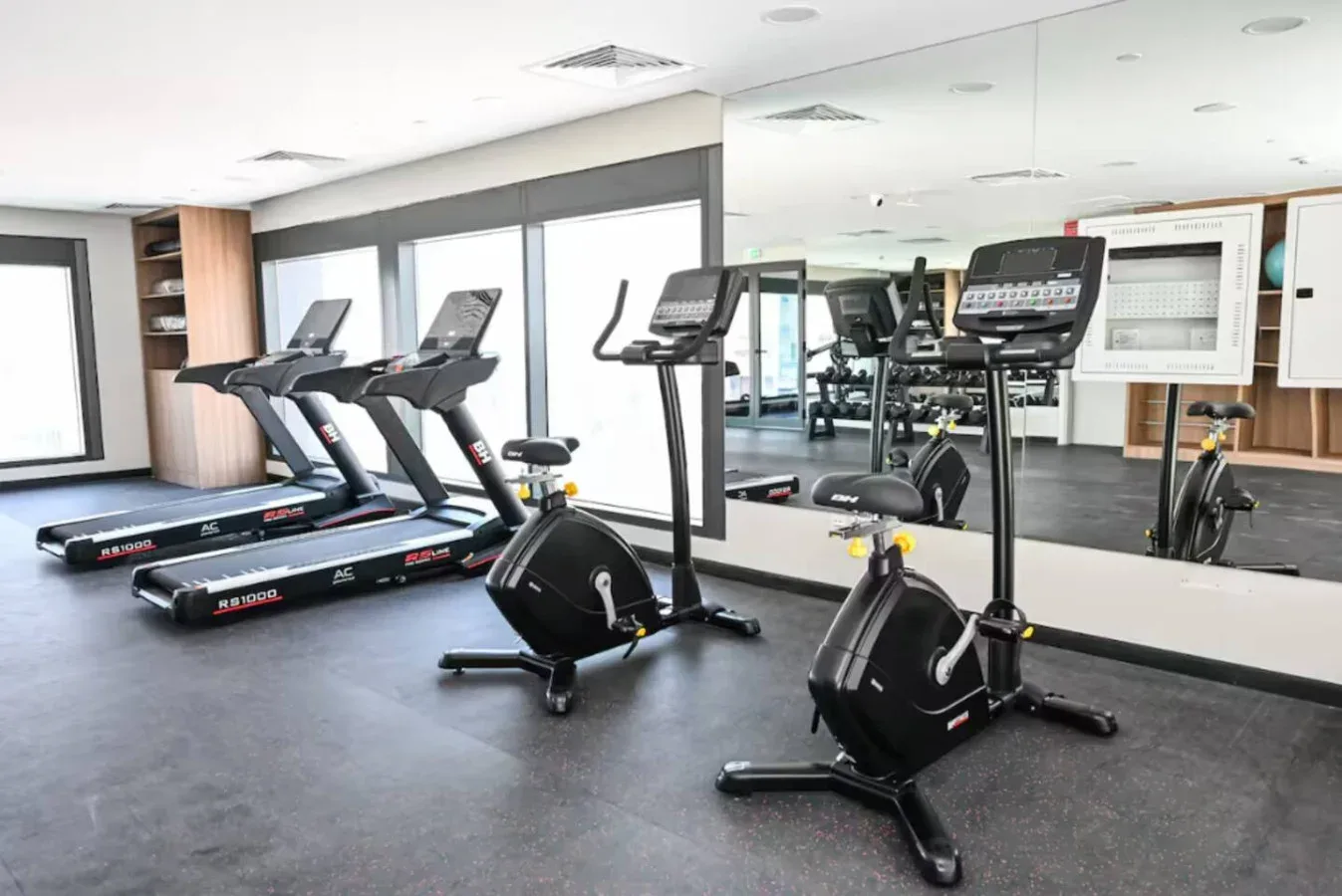 Una sala de fitness con cintas de correr y bicicletas estáticas.