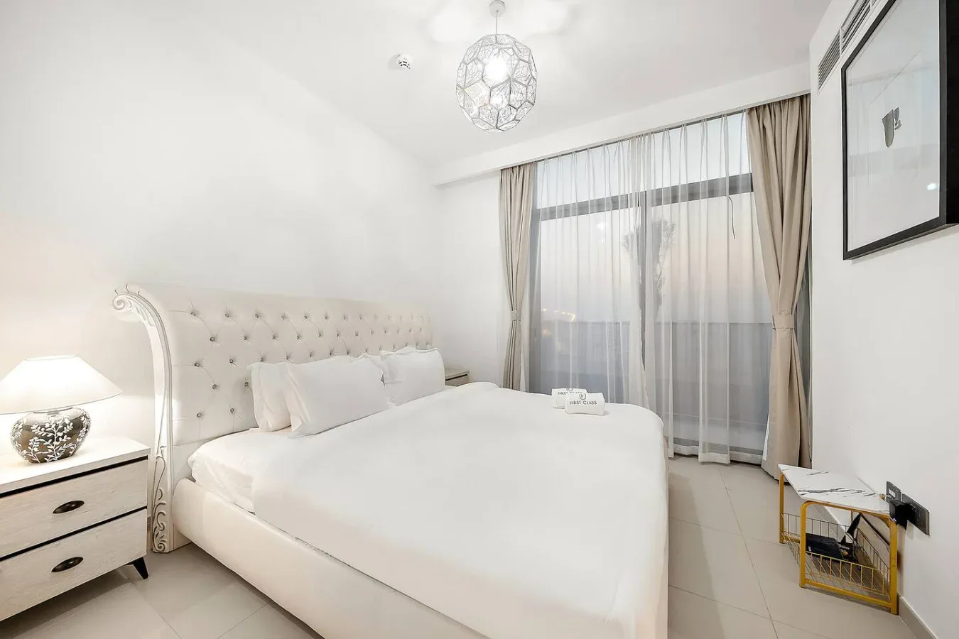 Un dormitorio luminoso con una cama grande y cortinas que cubren la ventana.