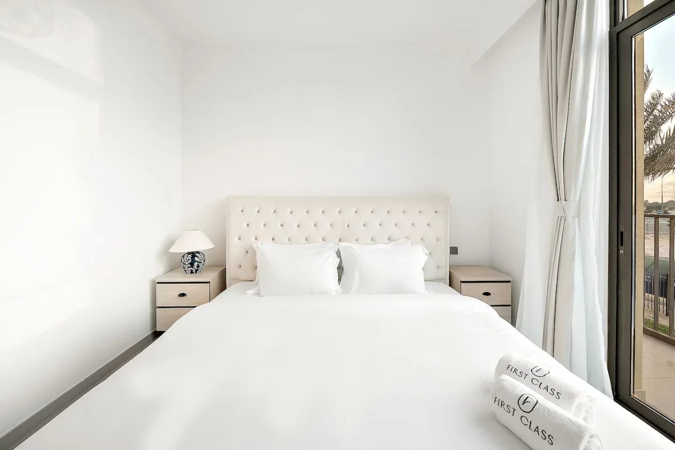 Un dormitorio luminoso con una cama bien tendida y una puerta de vidrio al lado.