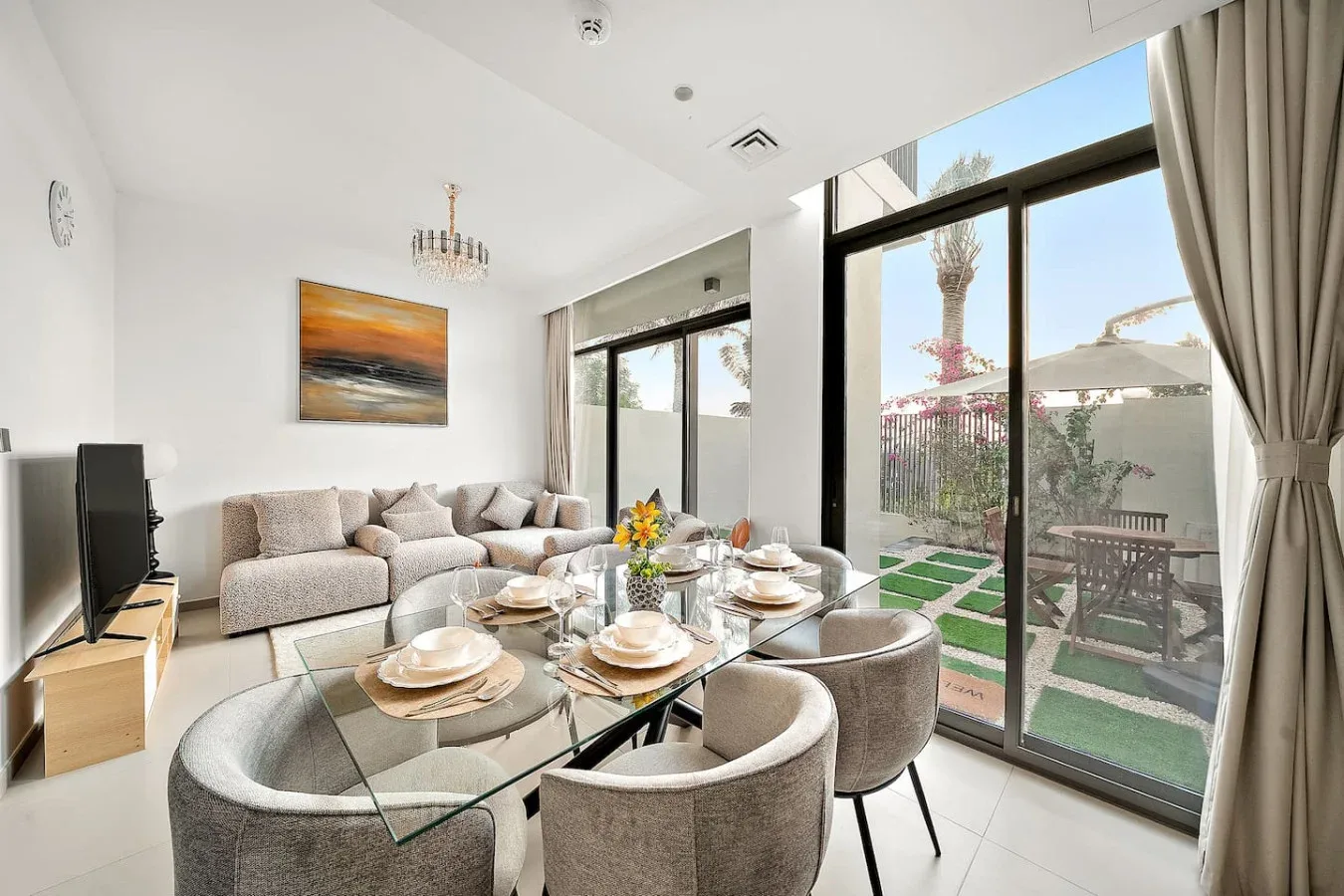 Una luminosa sala de estar y comedor con una zona de descanso y una mesa de comedor de vidrio.
