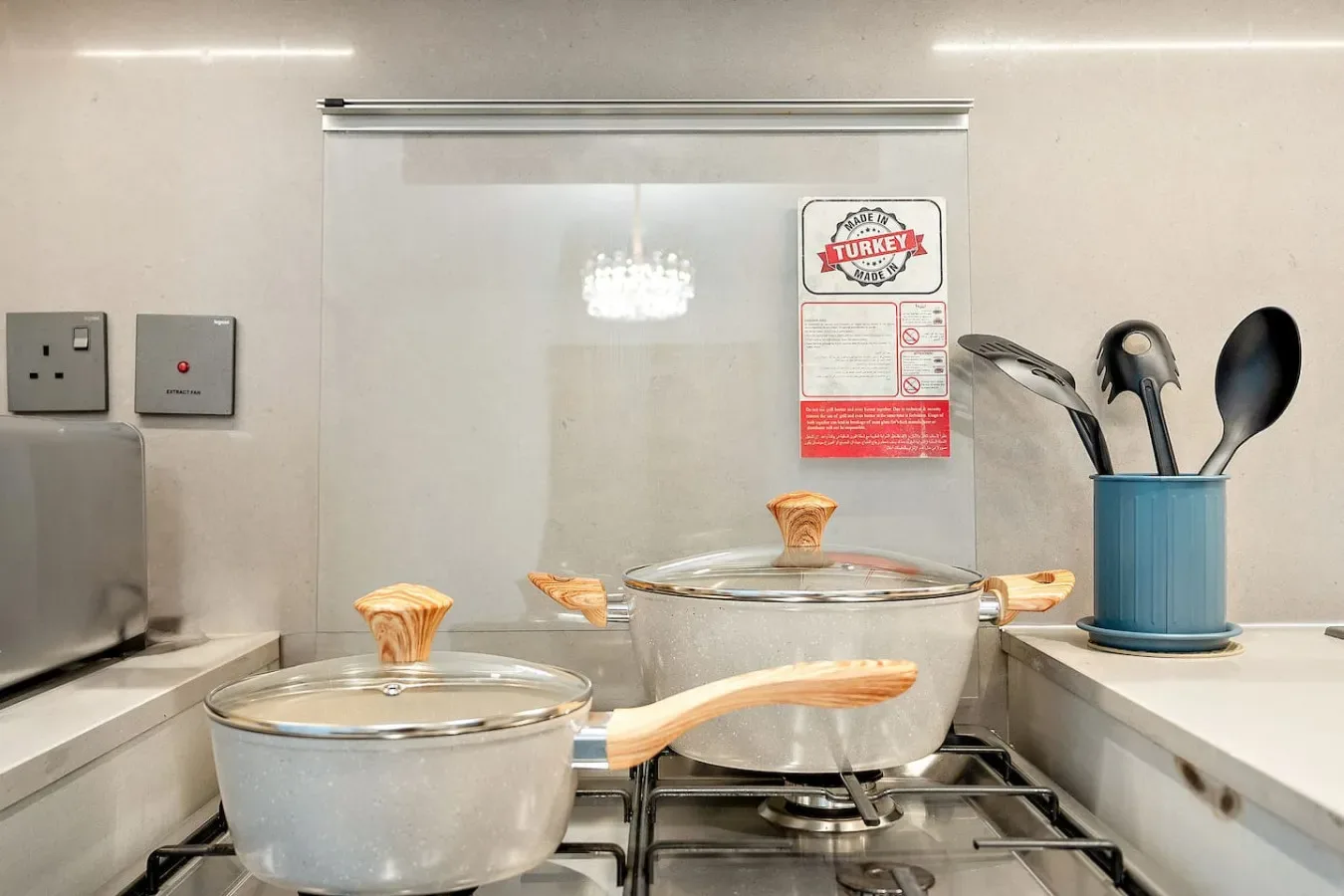 Una cocina con ollas de metal sobre la estufa y utensilios cerca.
