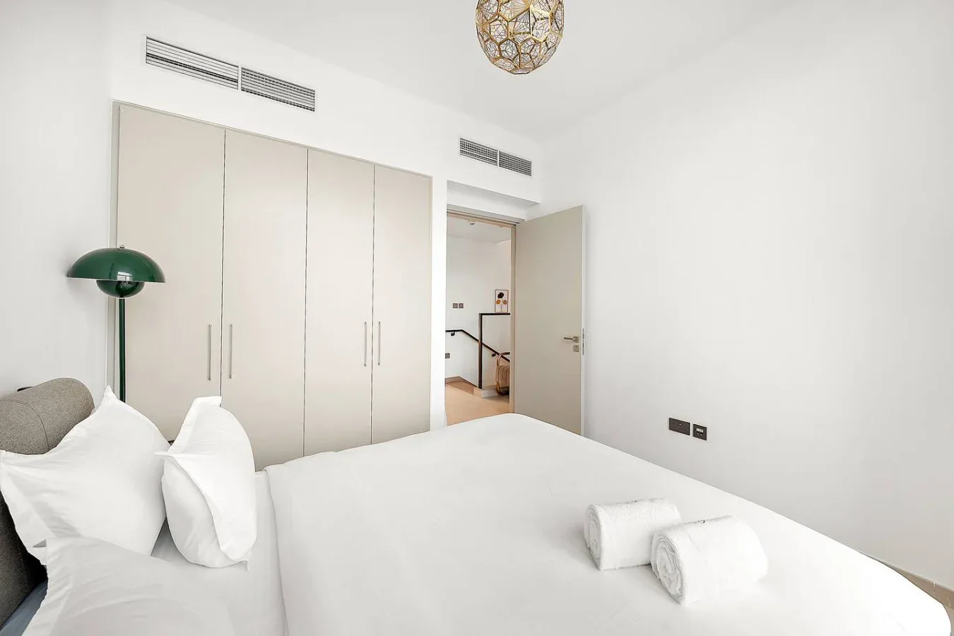 Un dormitorio luminoso con una cama grande y armarios empotrados.