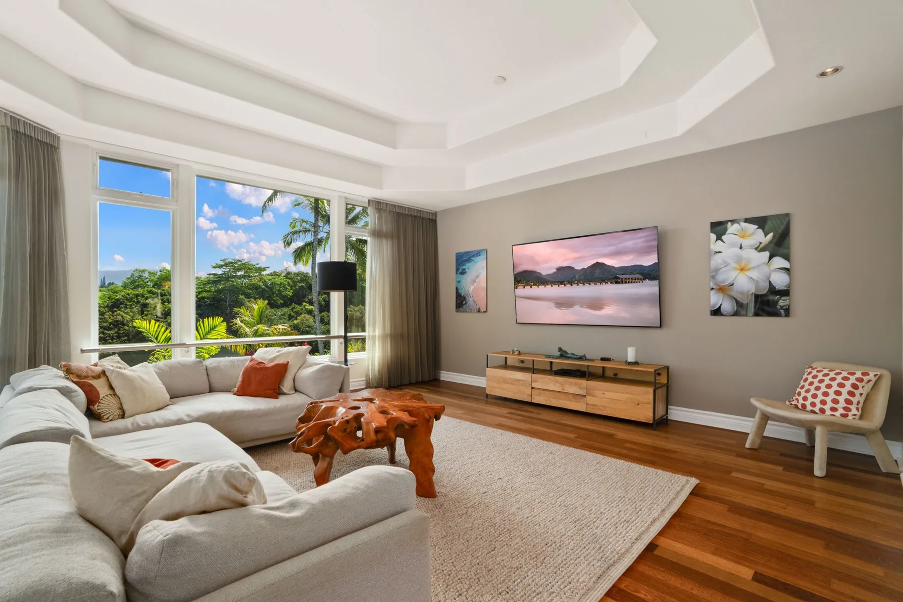 A bright living room with seating, a wooden coffee table, and framed wall art.