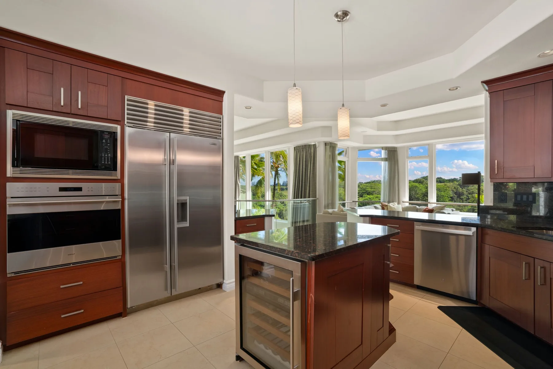 A bright kitchen with dark wood cabinetry, stainless steel appliances, and a central island.