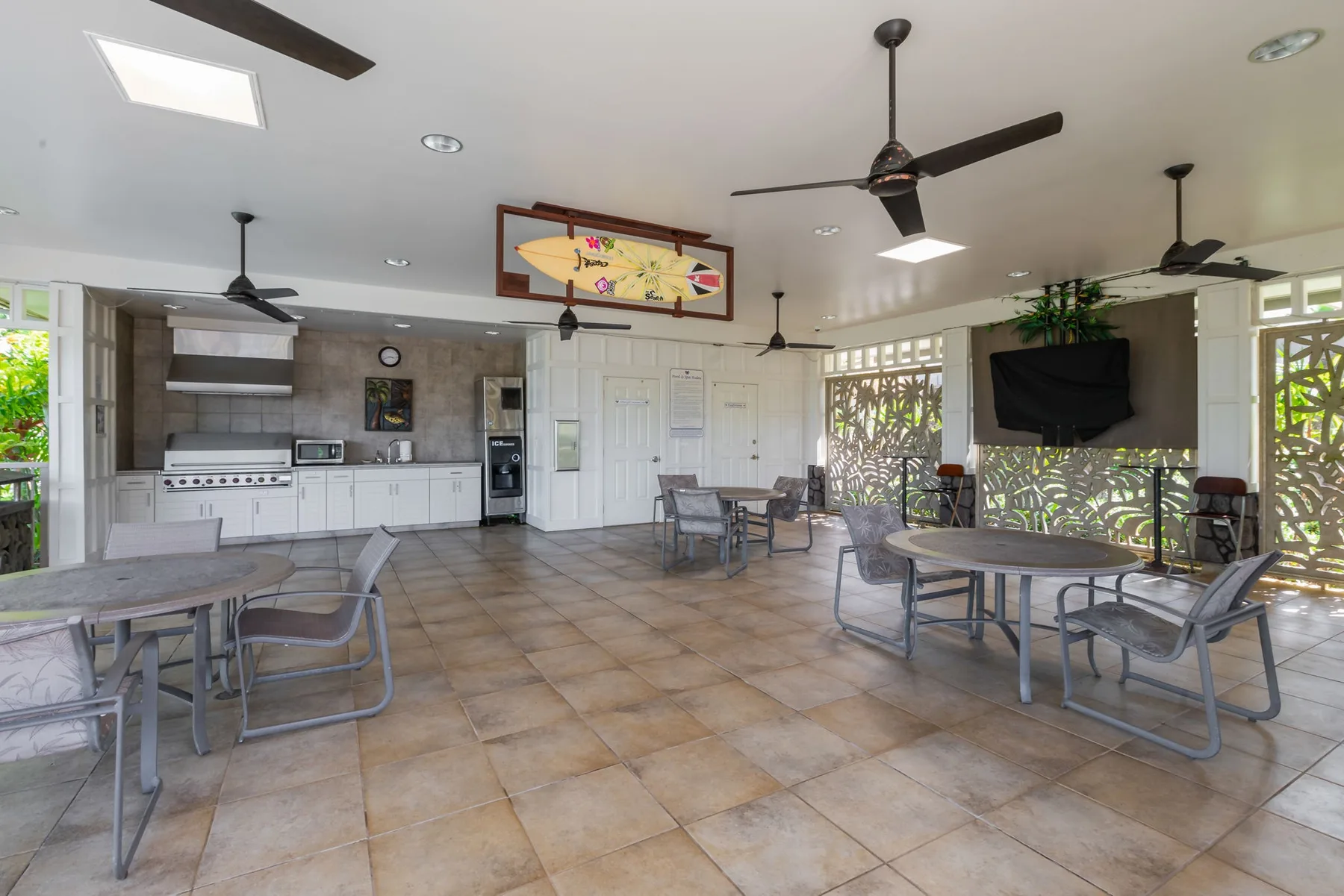 An open dining area with tables and seating beside a kitchen.