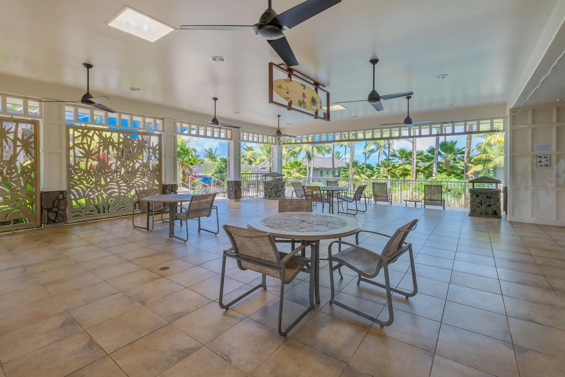 An open dining area with tables and seating beside large windows overlooking greenery.