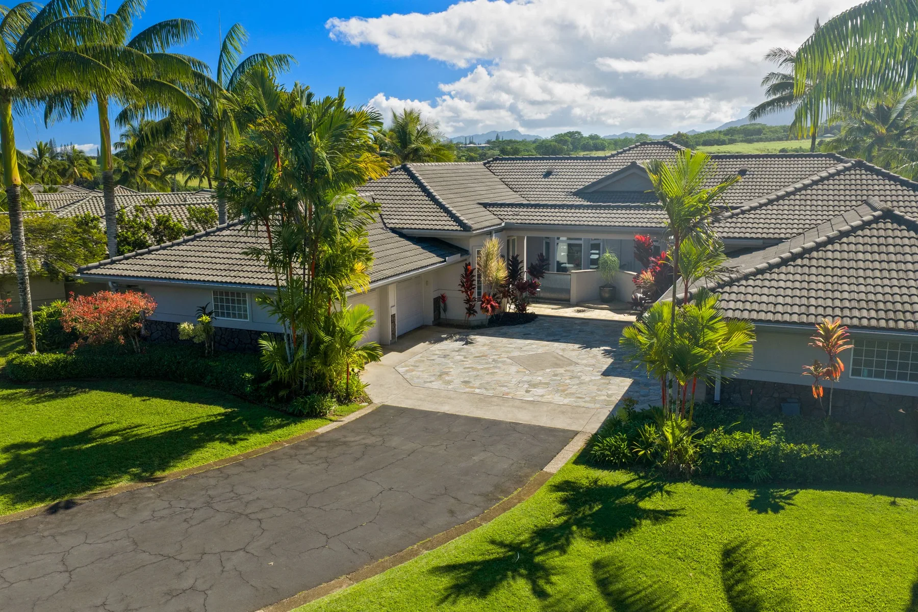 A low-rise building with a broad paved driveway and landscaped grounds.