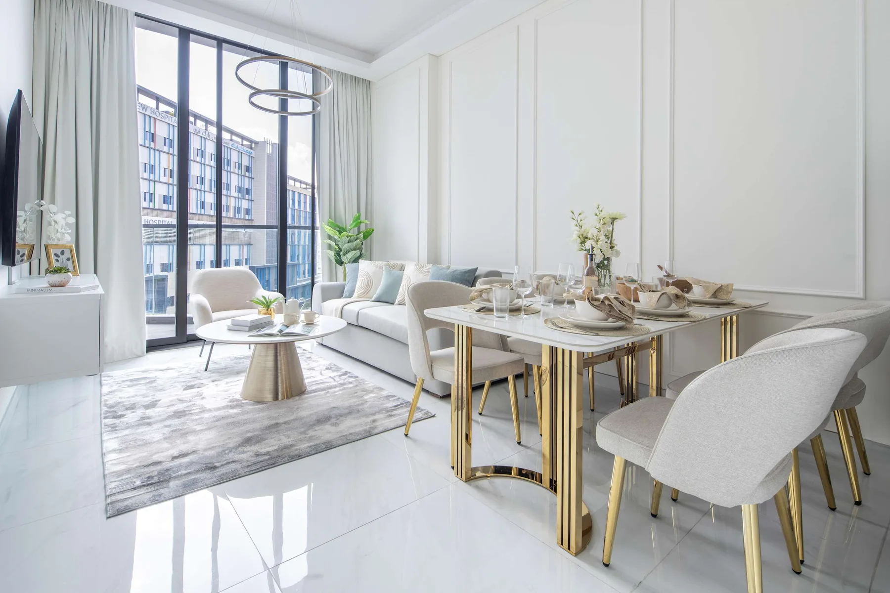 A bright living and dining area with seating beside large windows.
