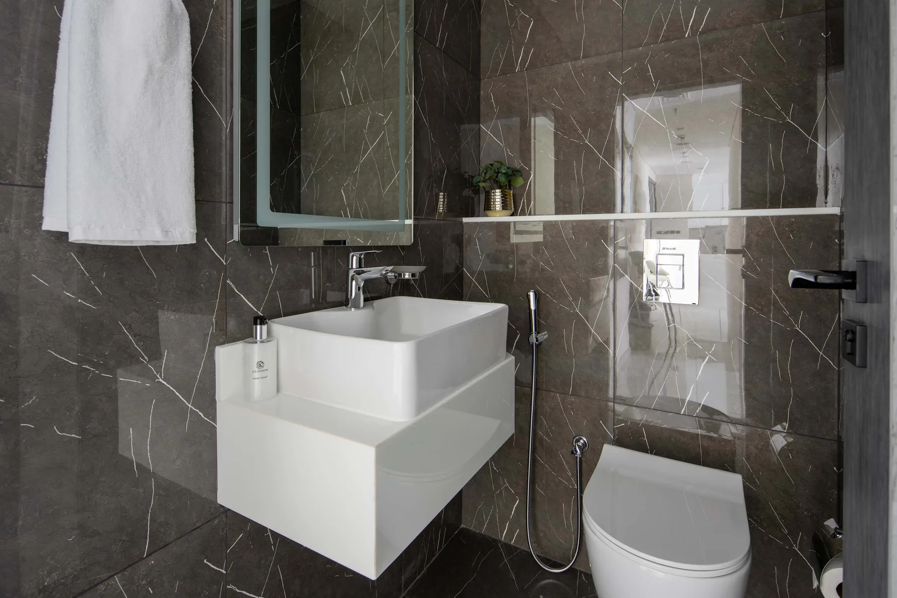 A modern bathroom with a white vessel sink and shower.