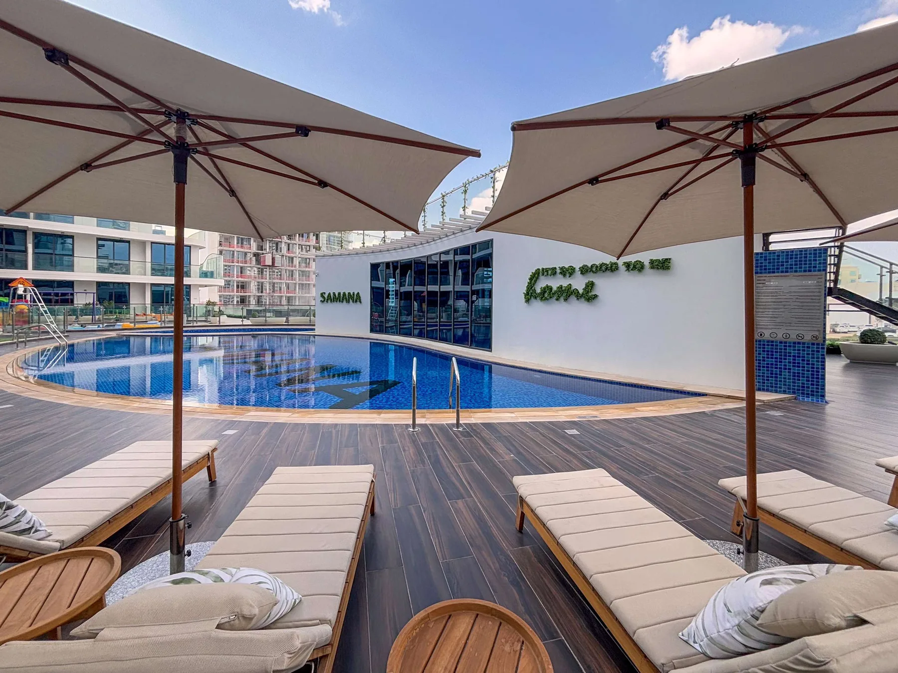 A pool deck with lounge seating and large shade umbrellas.
