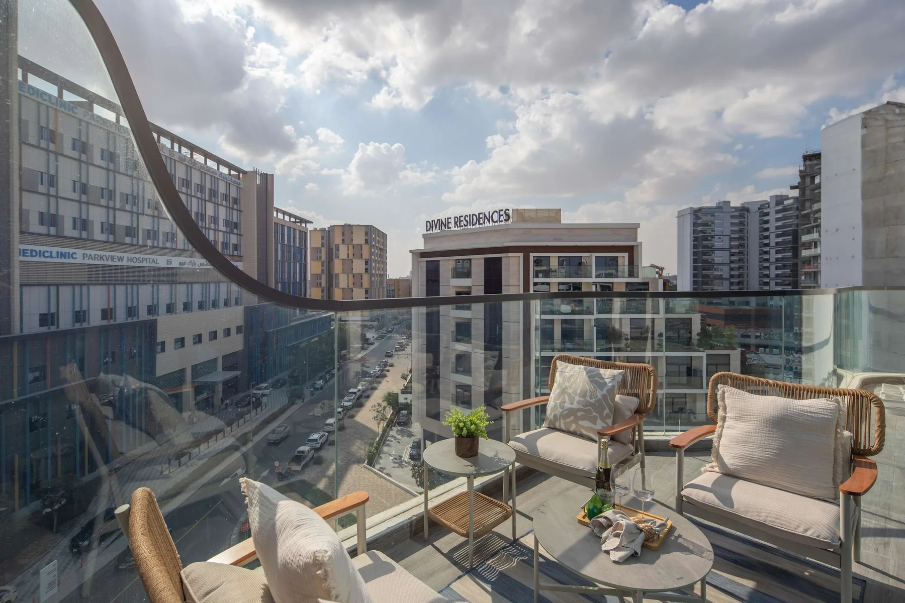 A balcony seating area overlooks nearby buildings beneath a cloudy sky.