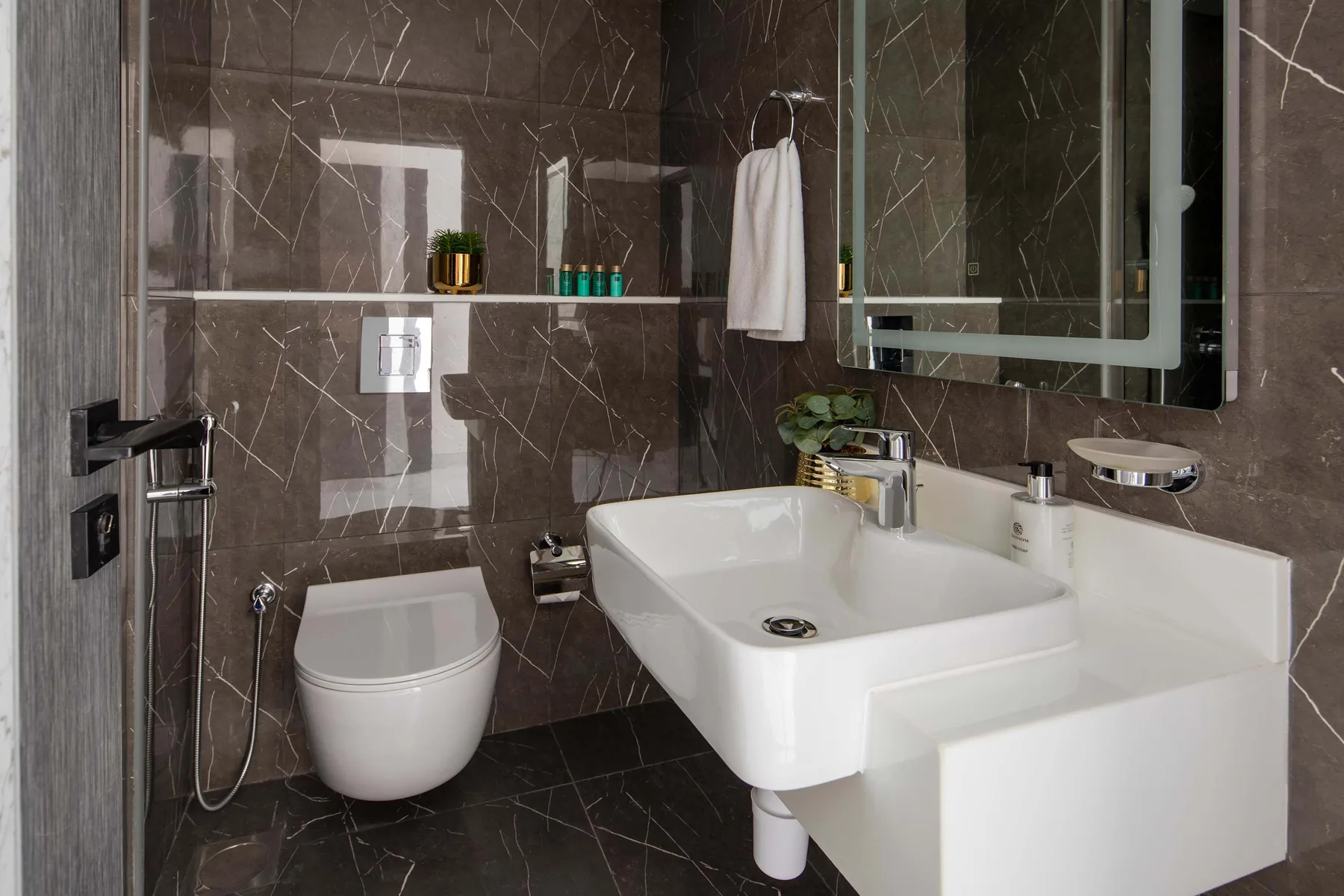 A modern bathroom with a wall-mounted sink and toilet.