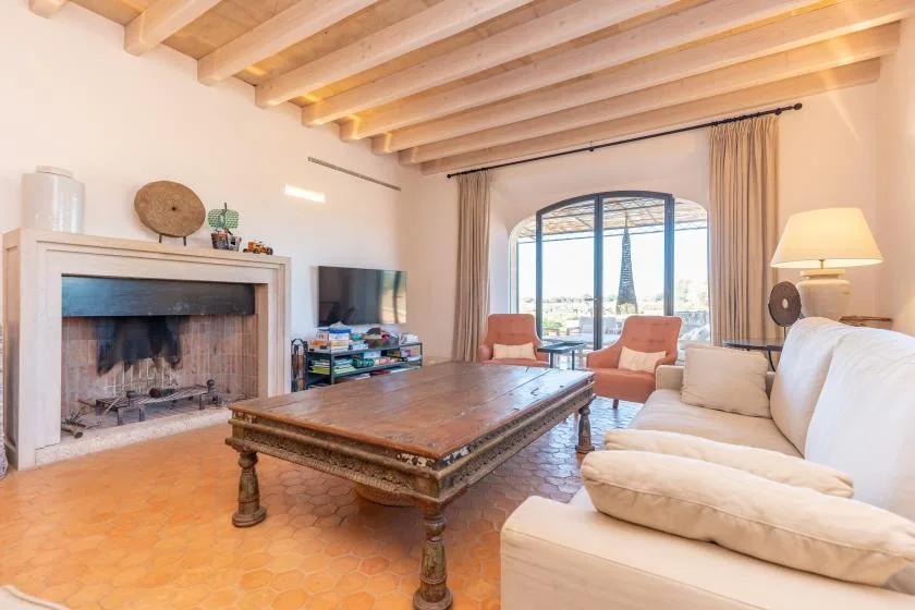 Una sala de estar luminosa con chimenea, asientos y una mesa de centro grande.